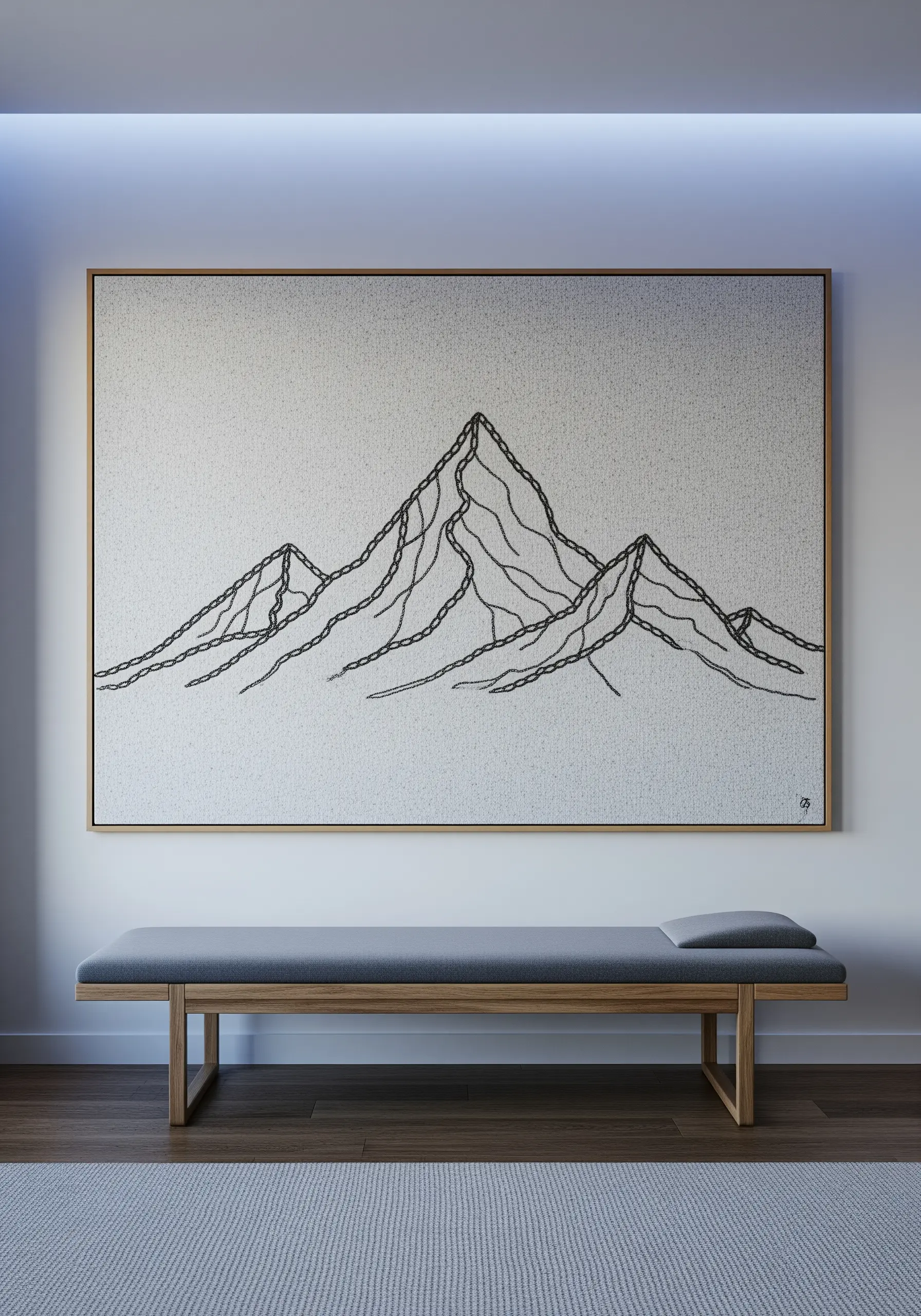 A large framed embroidery of a mountain range, using varied stitch weights for depth.