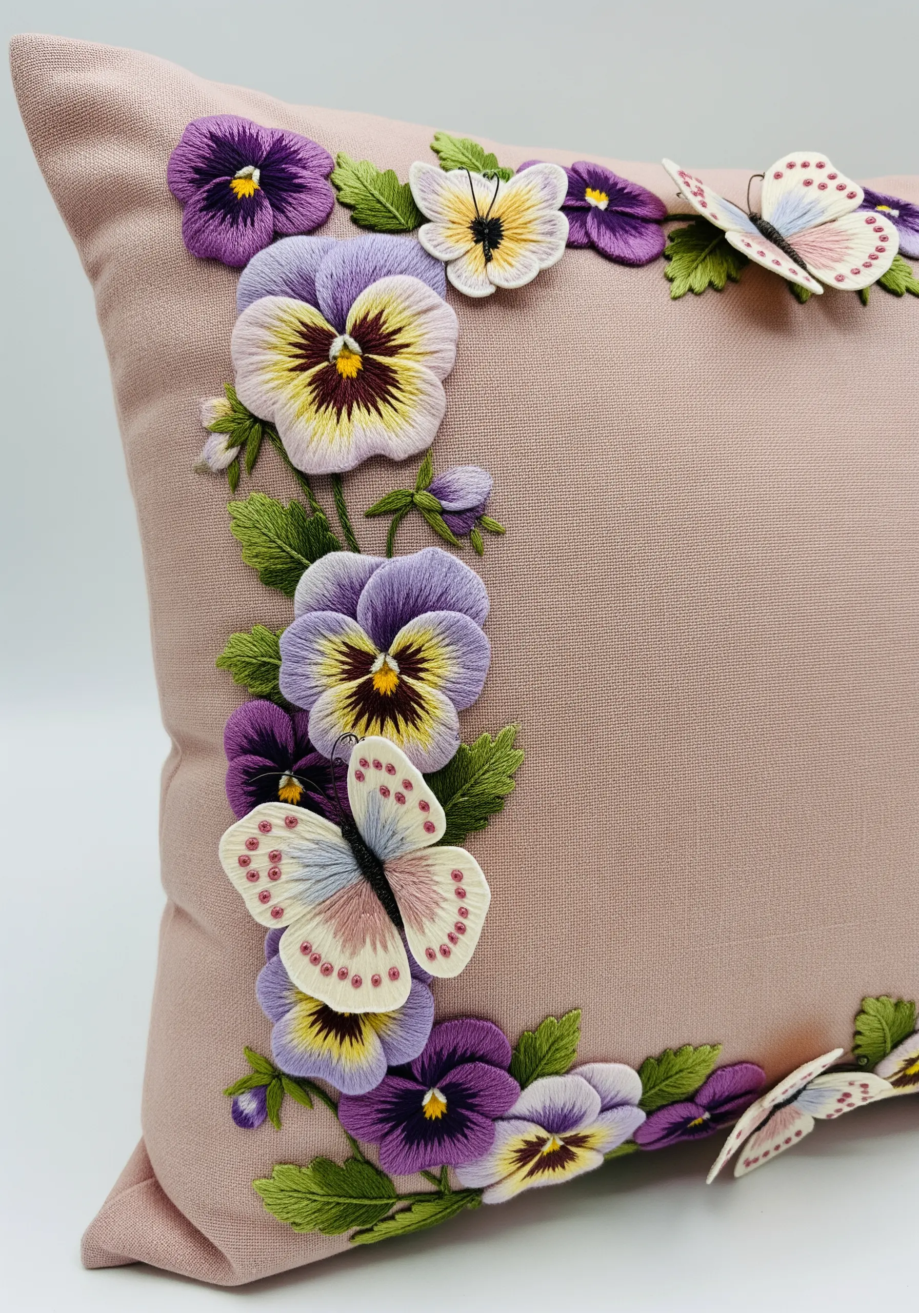 A border of embroidered pansies with 3D stumpwork butterflies lifting off the fabric