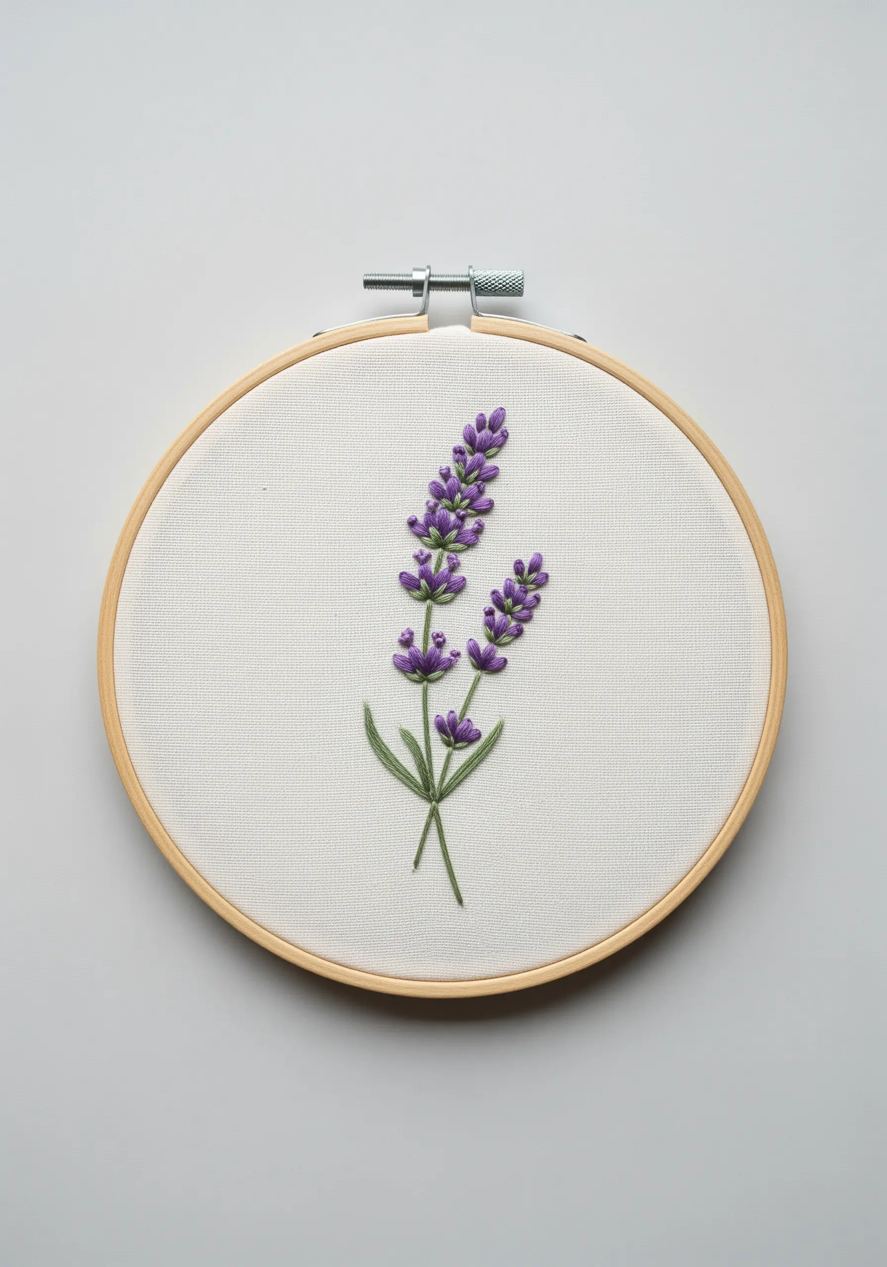 Two sprigs of lavender embroidered with purple French knots and green stem stitches.