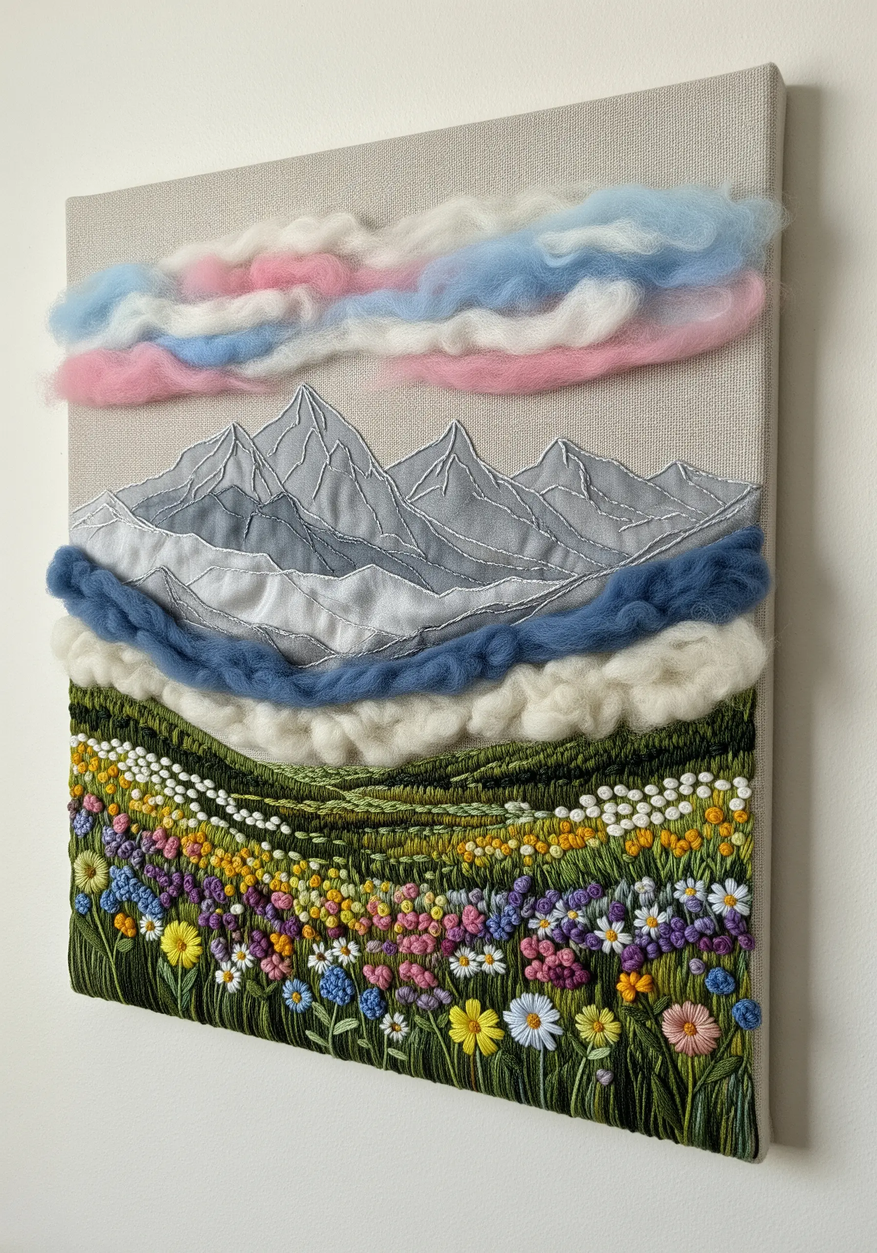 Mountain landscape embroidery with wool roving clouds and embroidered wildflowers.