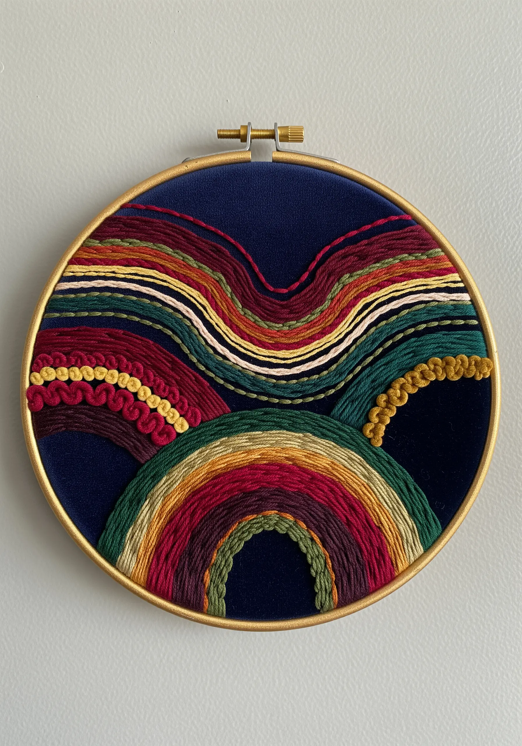 Abstract hoop art with layered, multicolored wavy lines using thick yarn and knots.