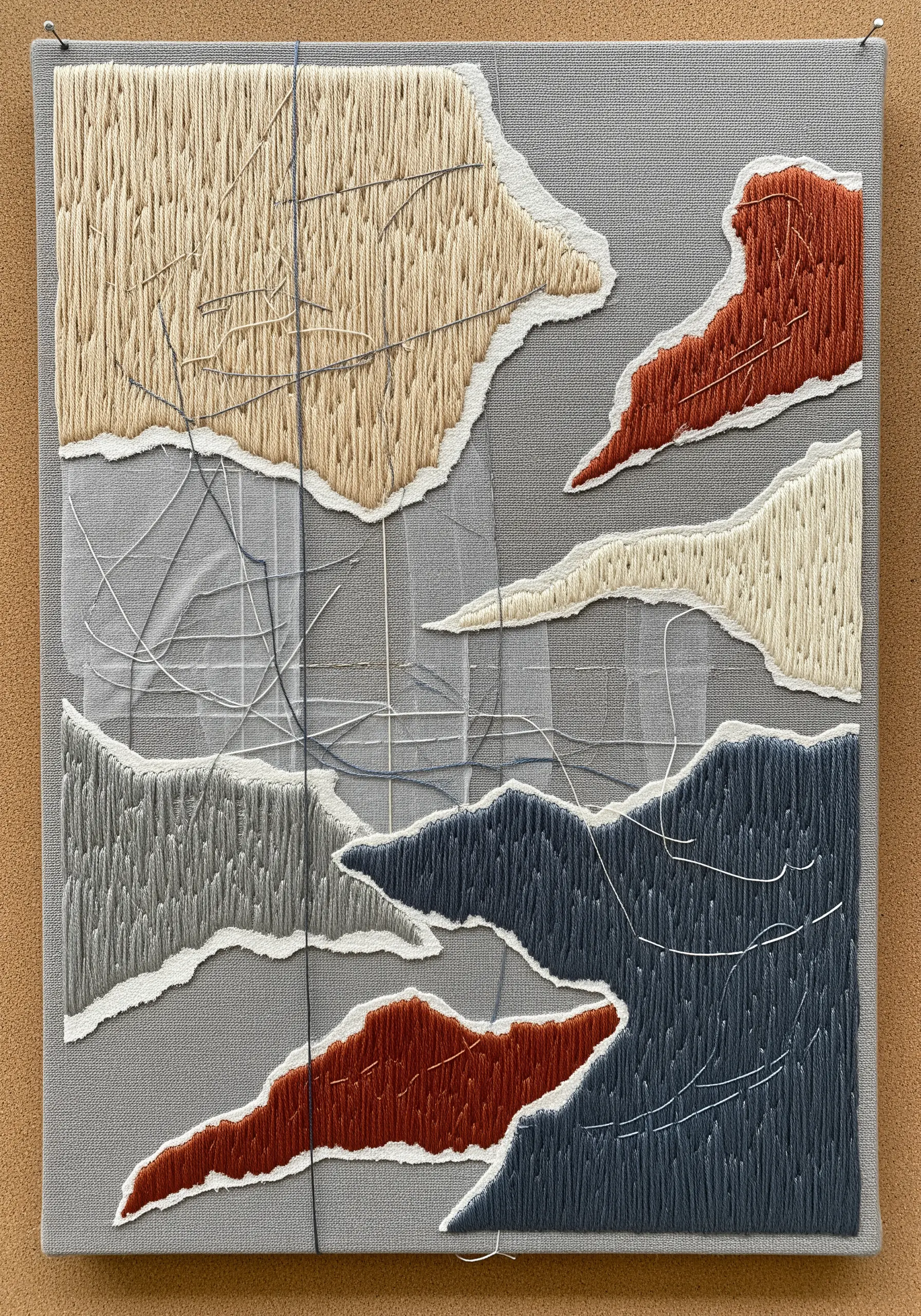 Abstract fabric collage embroidery with raw edges and dense vertical stitching.