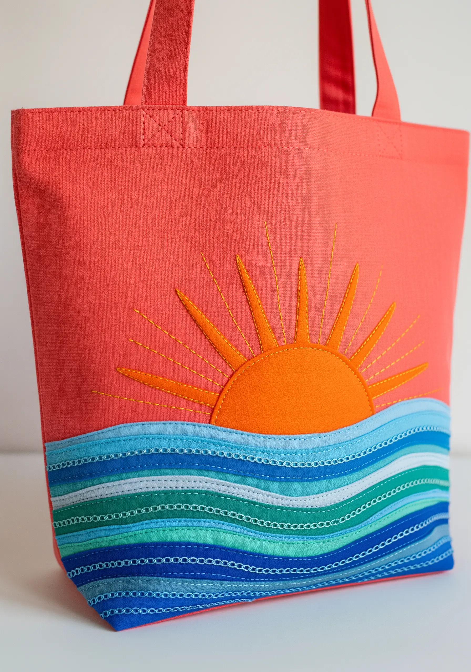 A sun and ocean scene created with layered fabric appliqué and decorative stitching.
