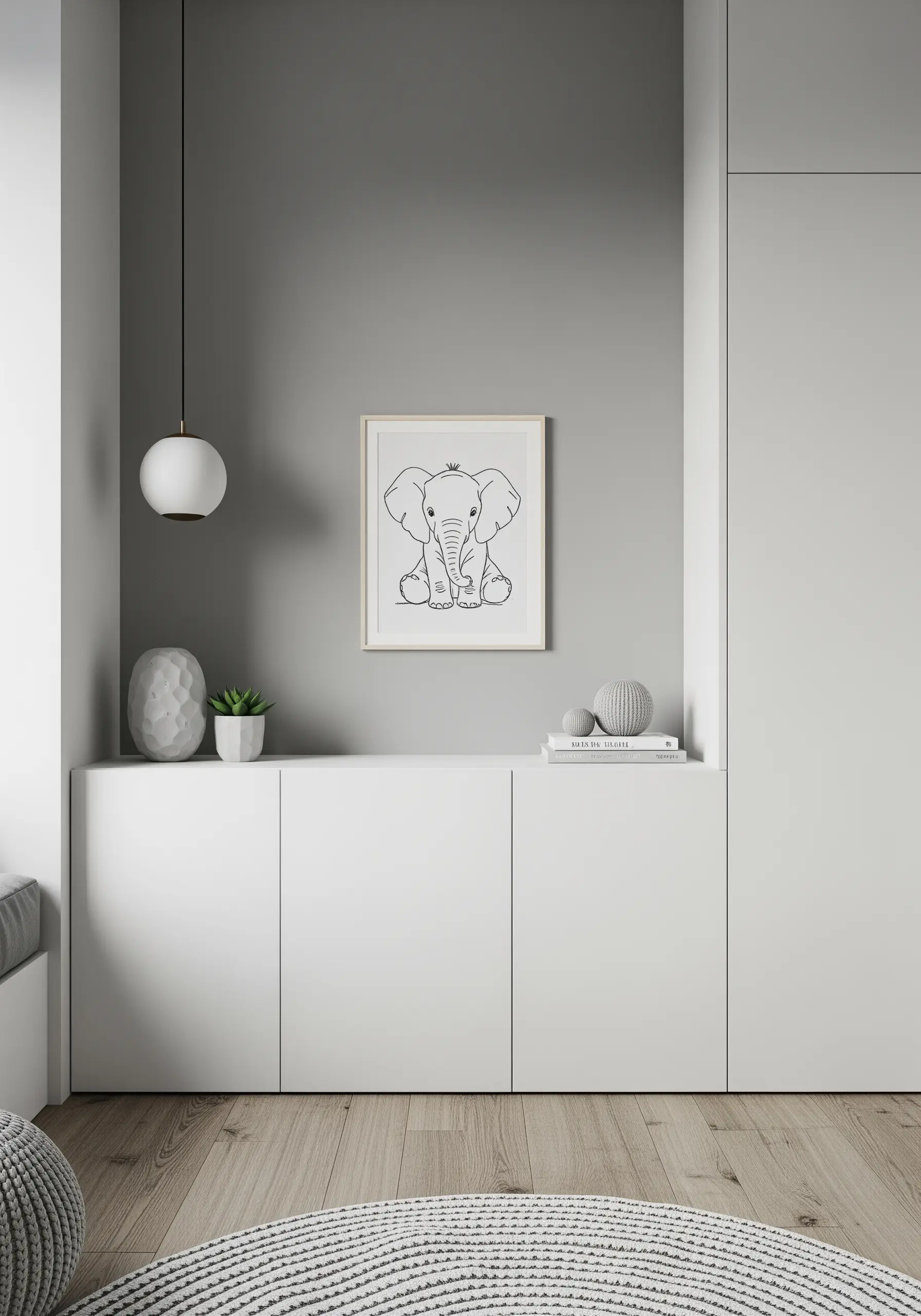 A simple line-art embroidery of a baby elephant with a tiny crown, framed and placed on a white cabinet.
