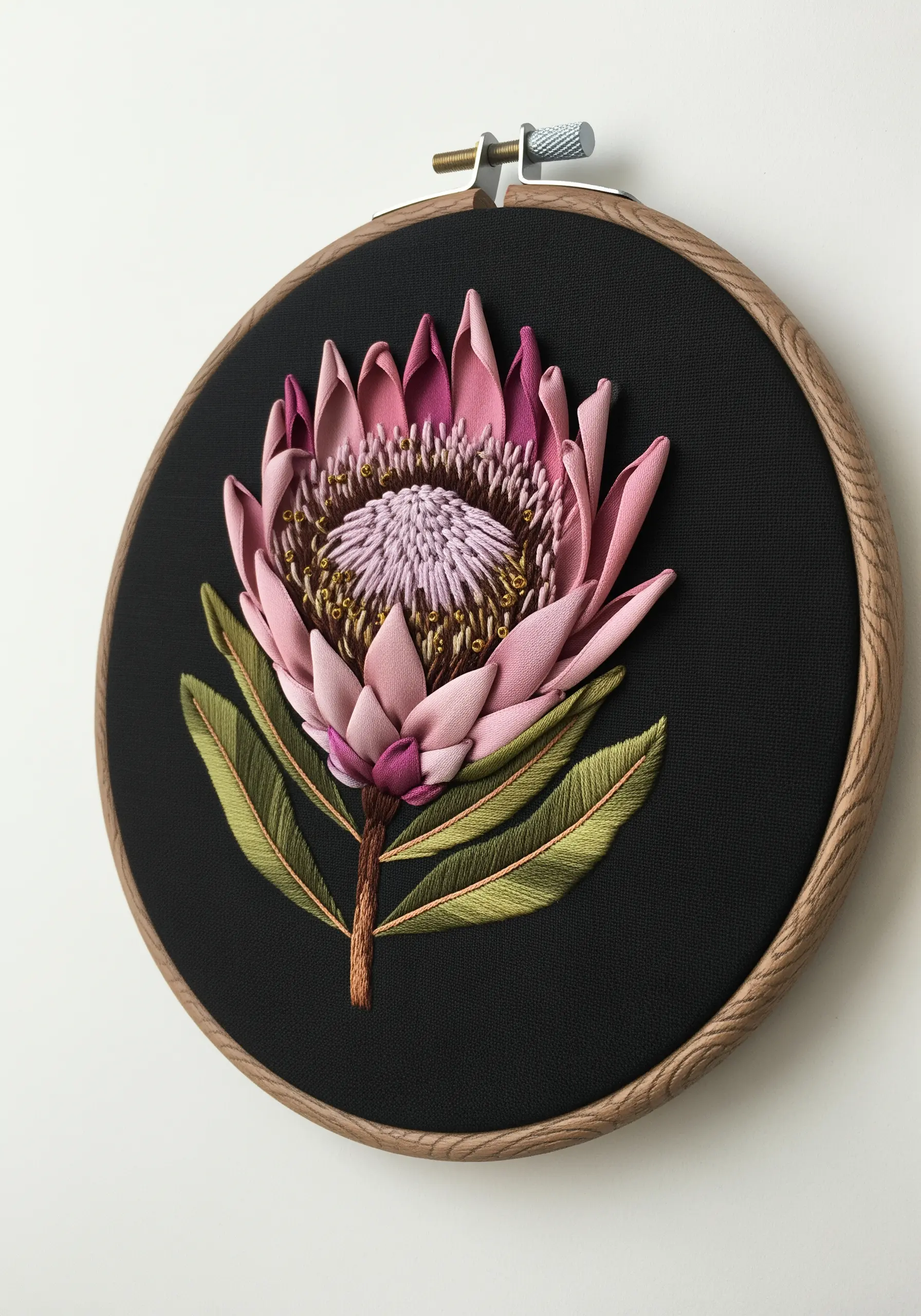 A dimensional protea flower made with folded pink ribbon and thread on black fabric.