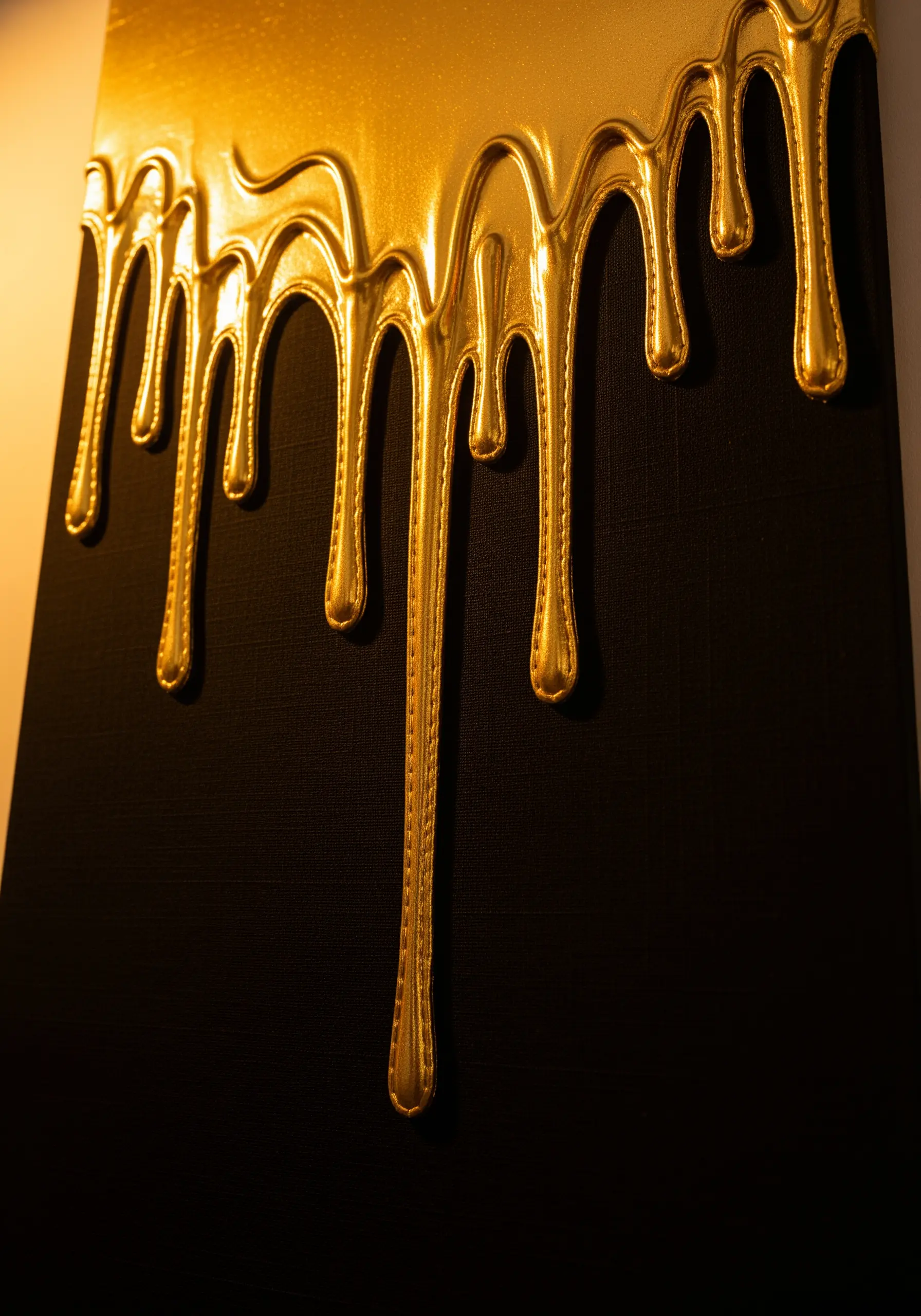 A close-up of a 3D embroidered piece showing thick, dripping gold against a black canvas.