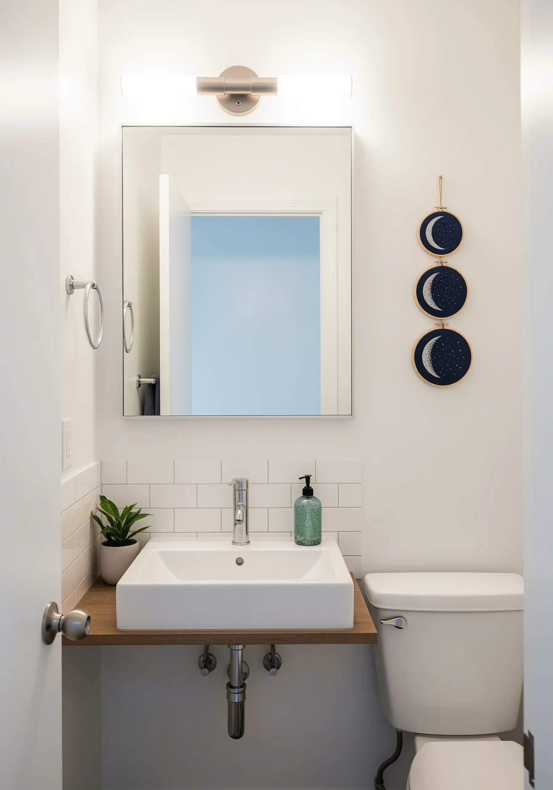 Three small embroidery hoops showing moon phases against a starry background.