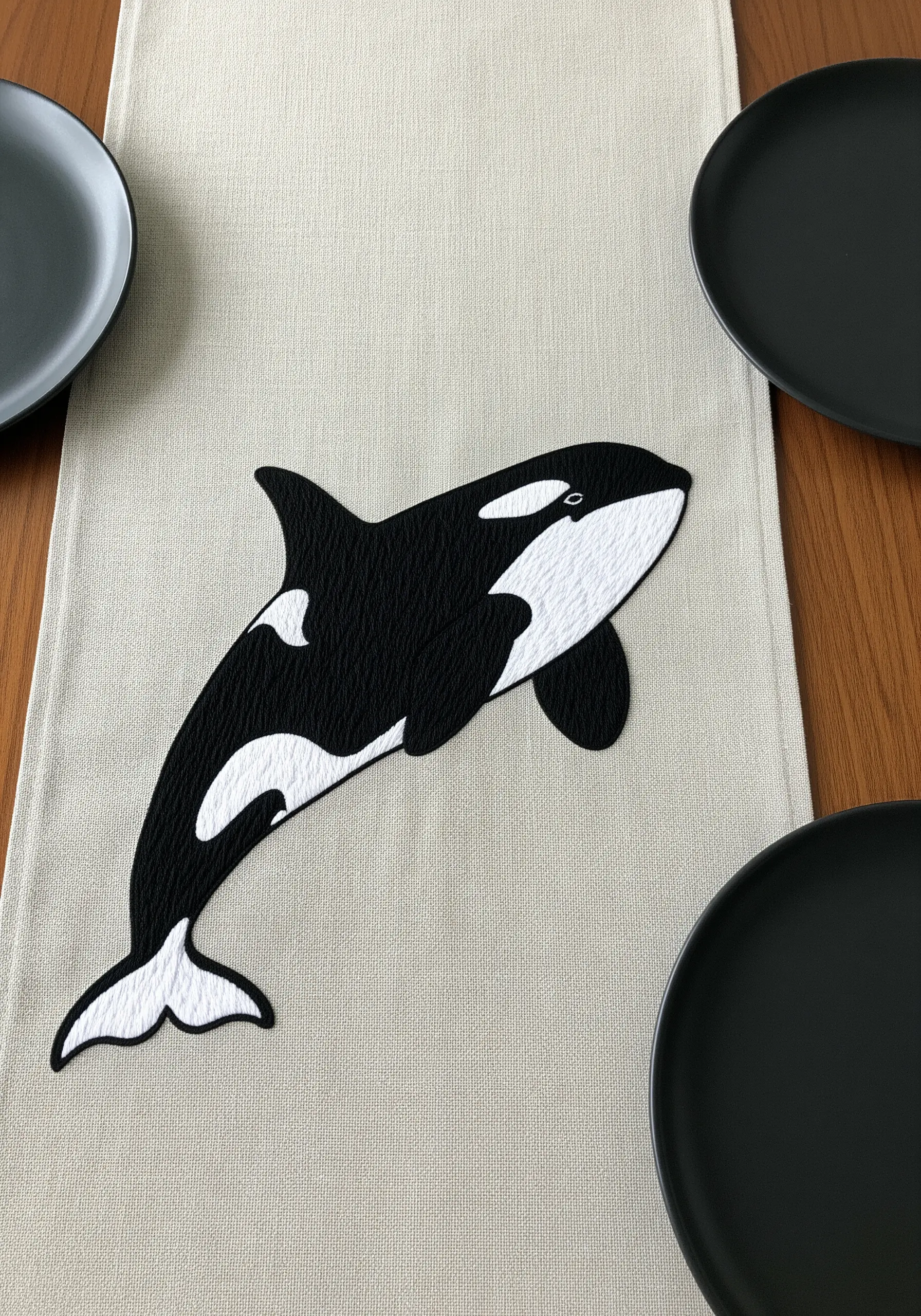 A graphic black and white orca on a neutral table runner, showcasing sharp edges.