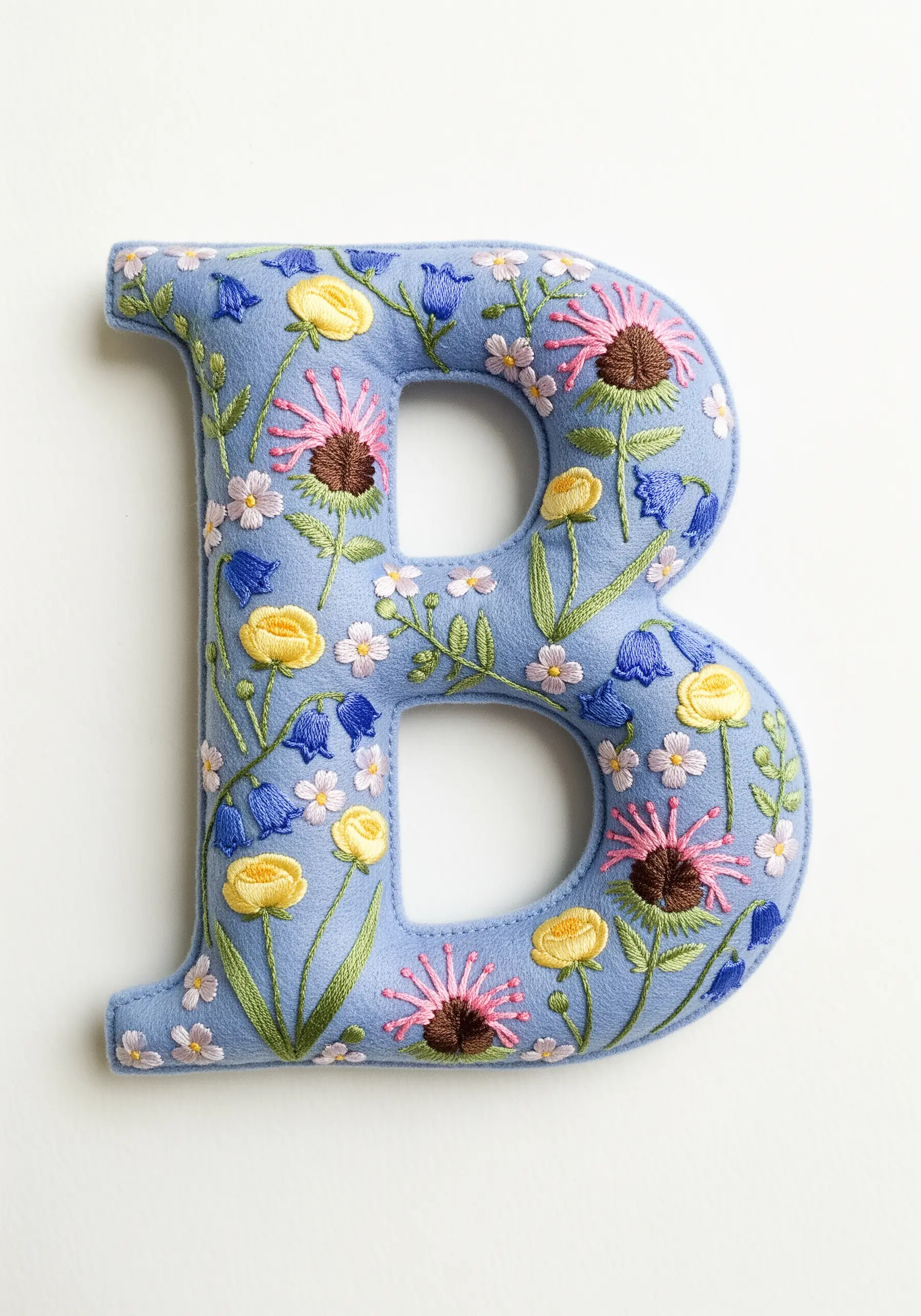 A felt letter 'B' covered in a dense pattern of colorful embroidered wildflowers.