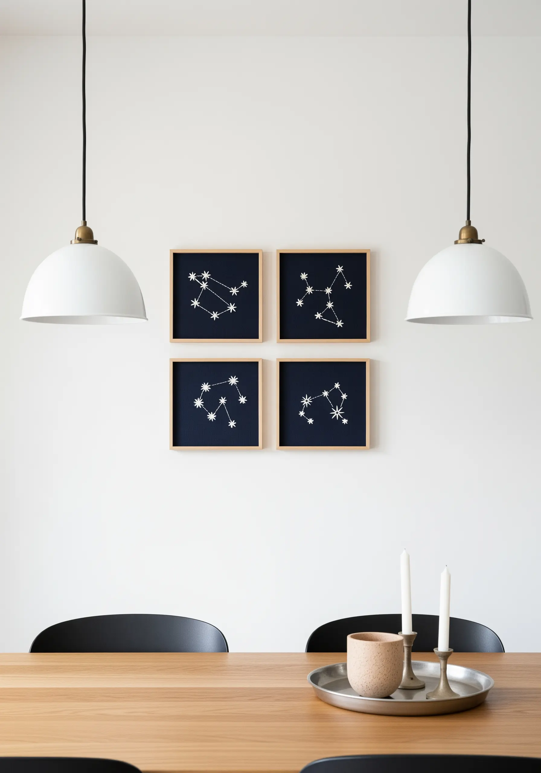 Four framed embroideries of star constellations on navy fabric, hung in a grid.