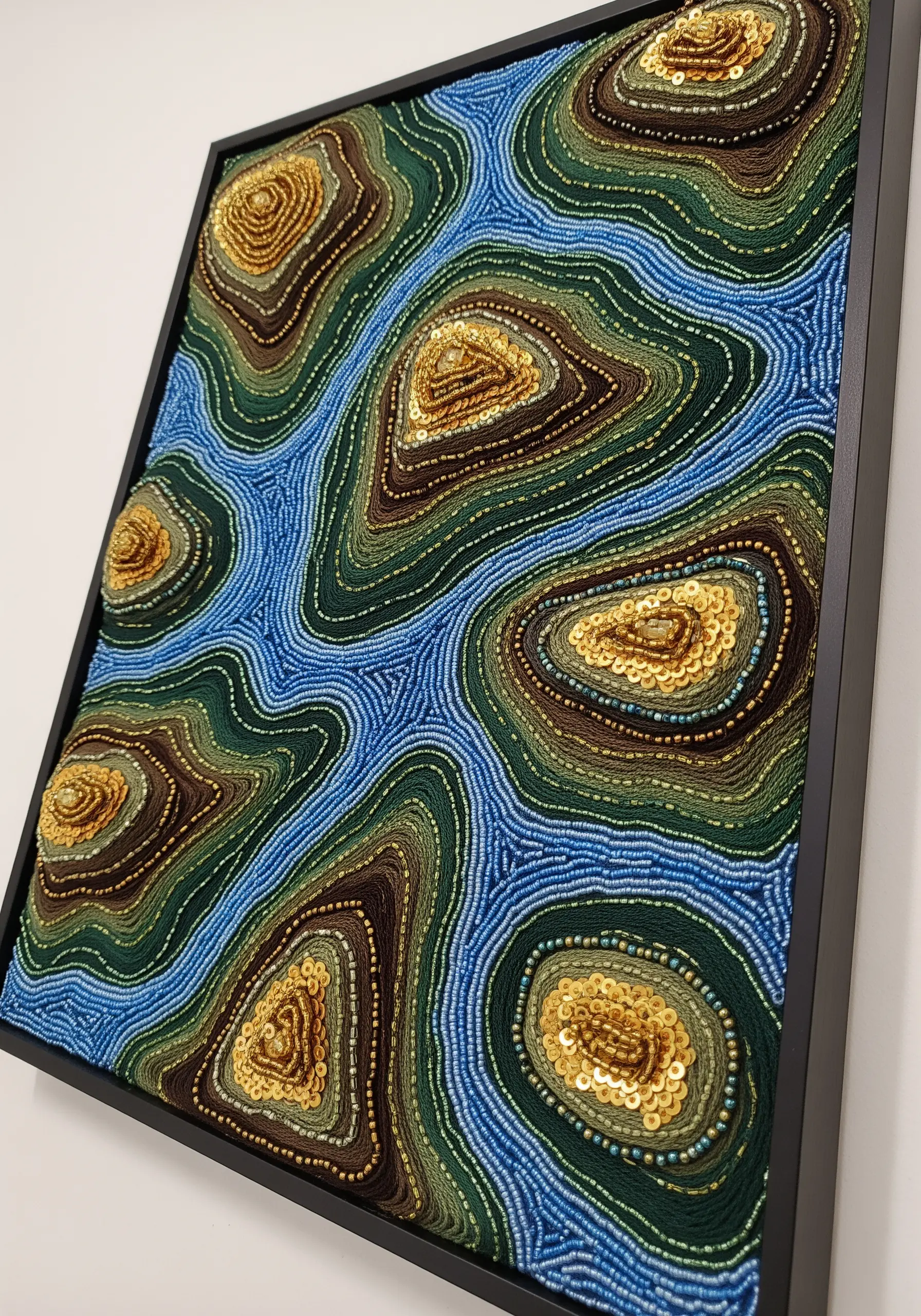 Topographical design using couched thread, seed beads, and sequins.