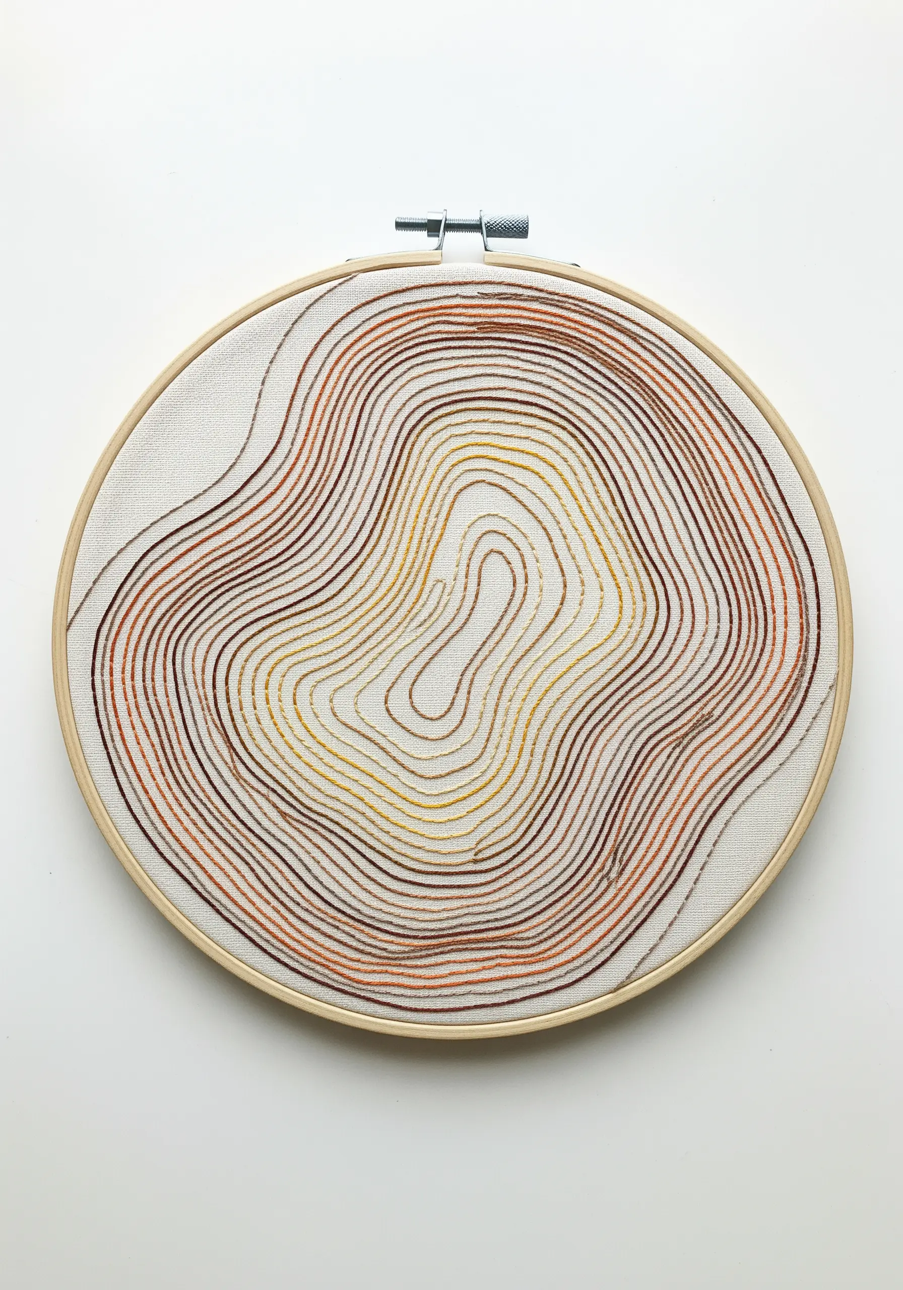 Abstract topographic line embroidery in a warm brown, orange, and yellow gradient.