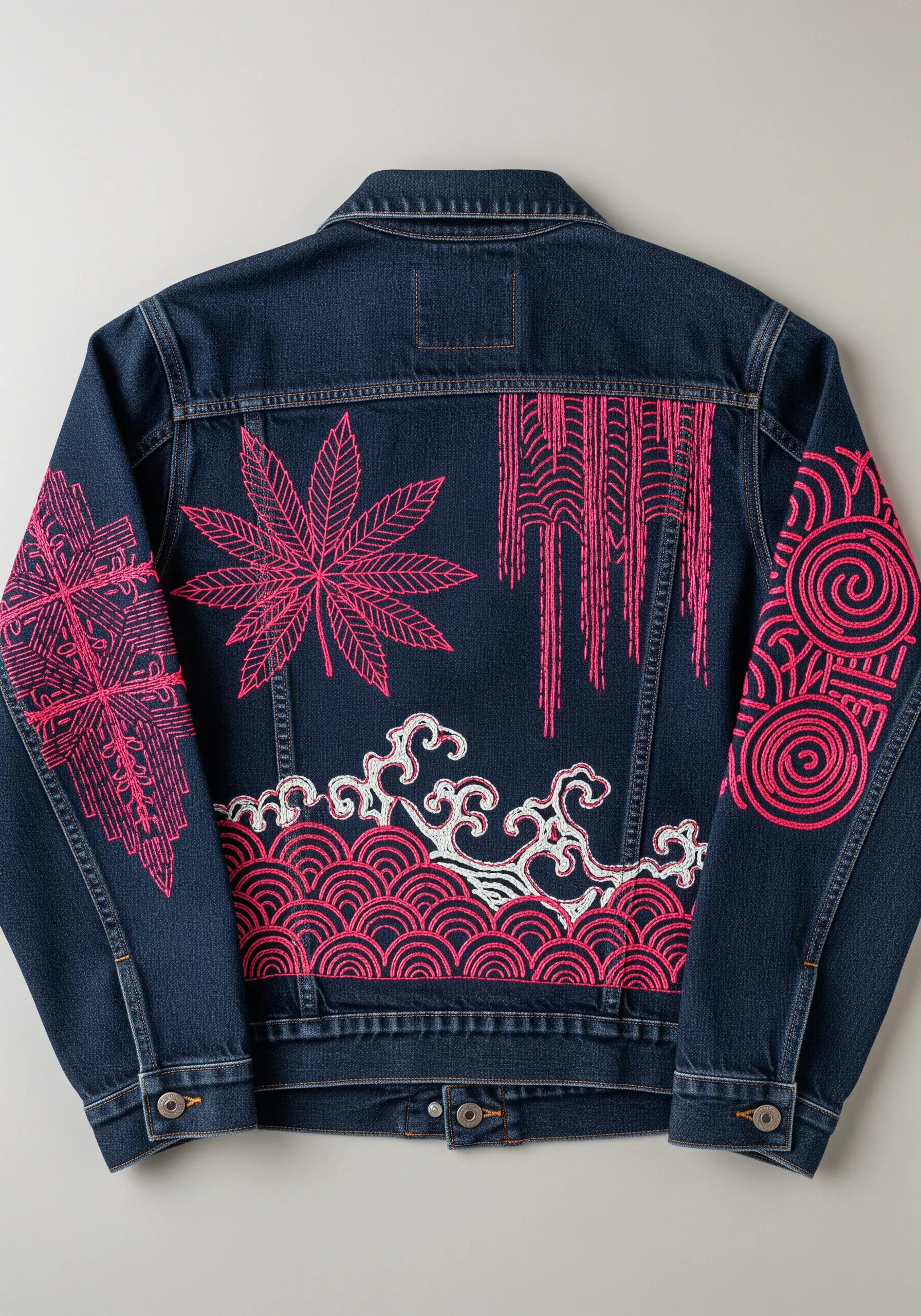 Denim jacket with bold, graphic embroidery in hot pink thread covering the back and sleeves.