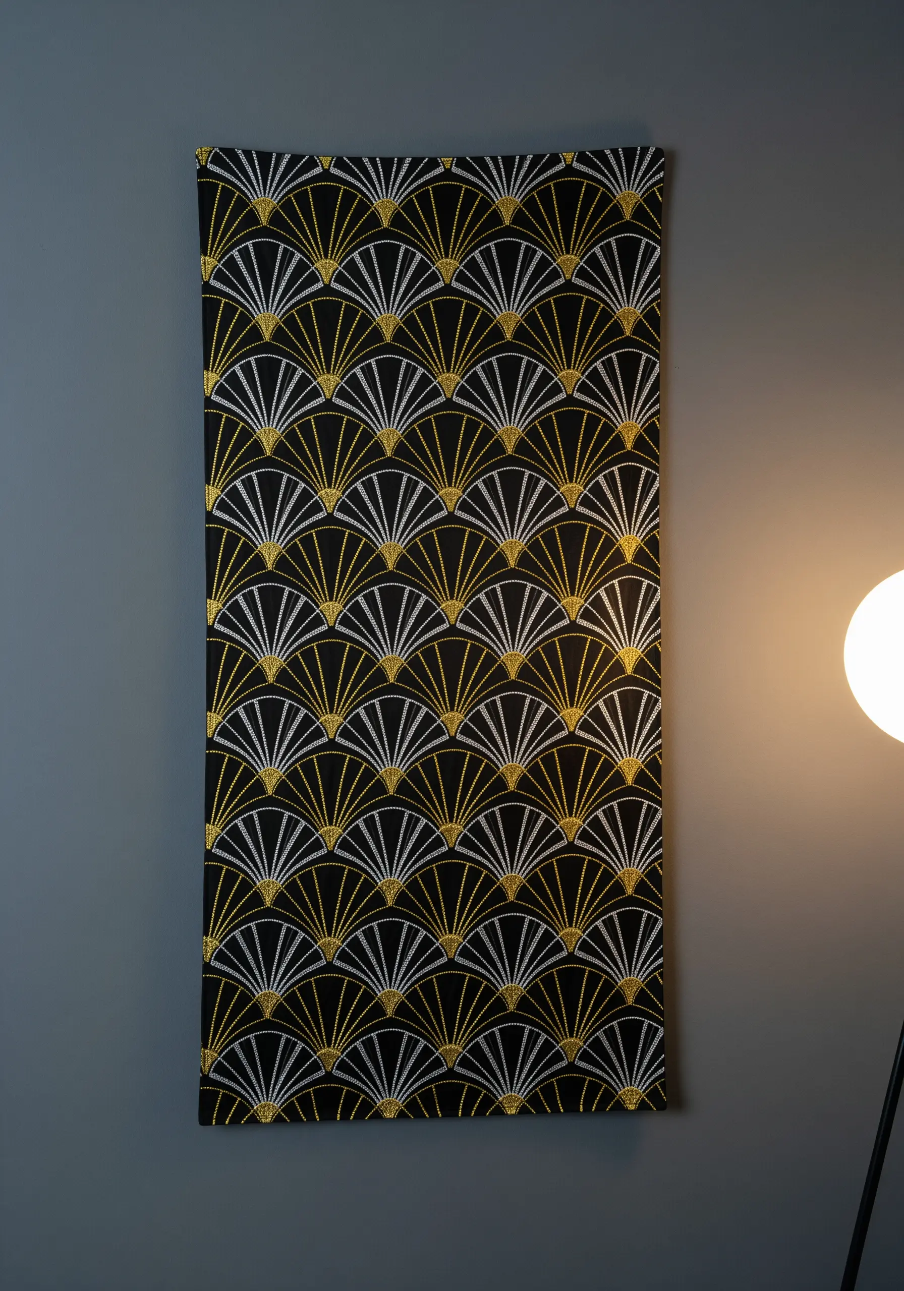 A narrow wall hanging with a repeating Art Deco fan pattern in gold, silver, and white thread.