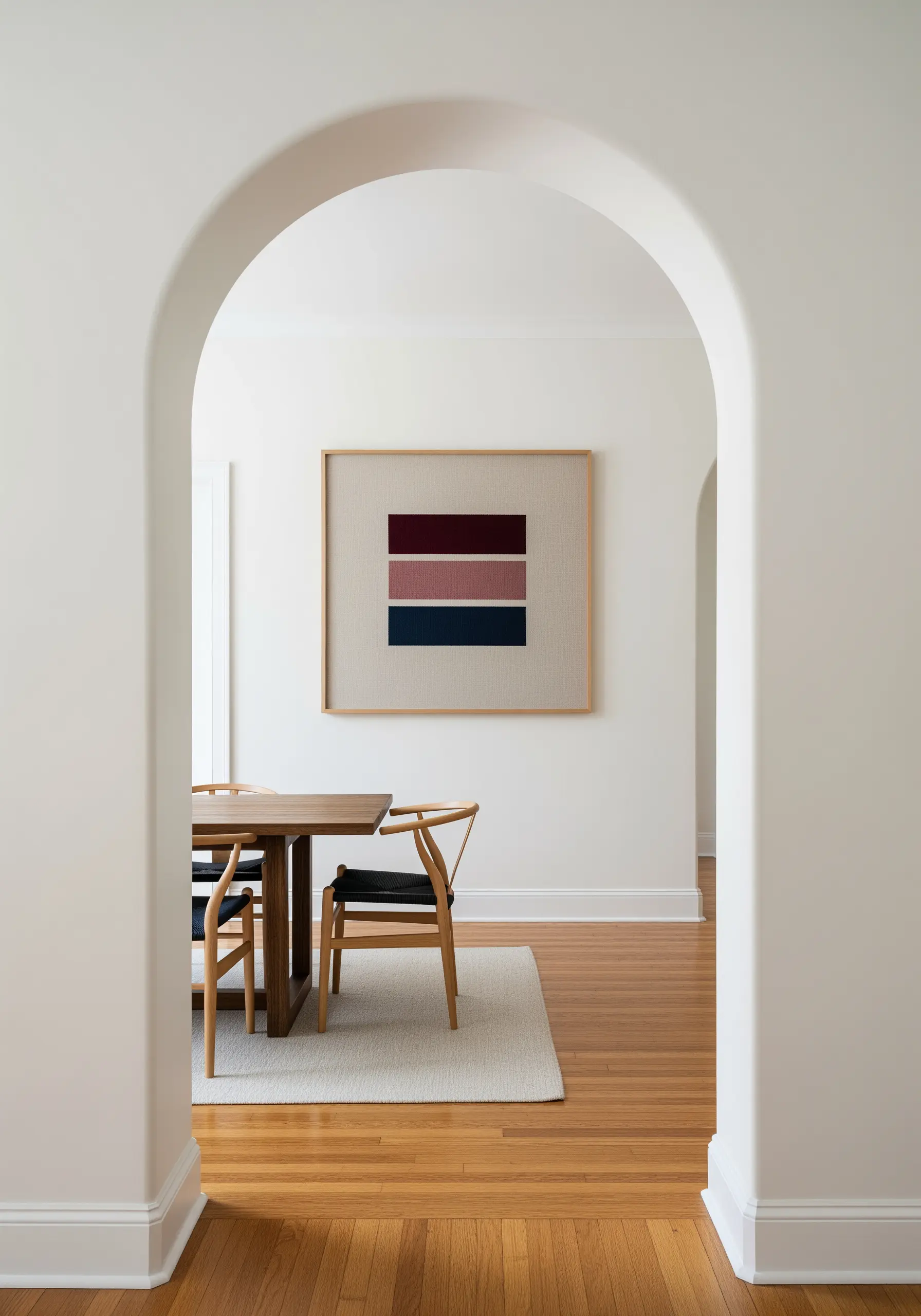 A minimalist embroidery of three horizontal color blocks in muted tones, framed in an archway