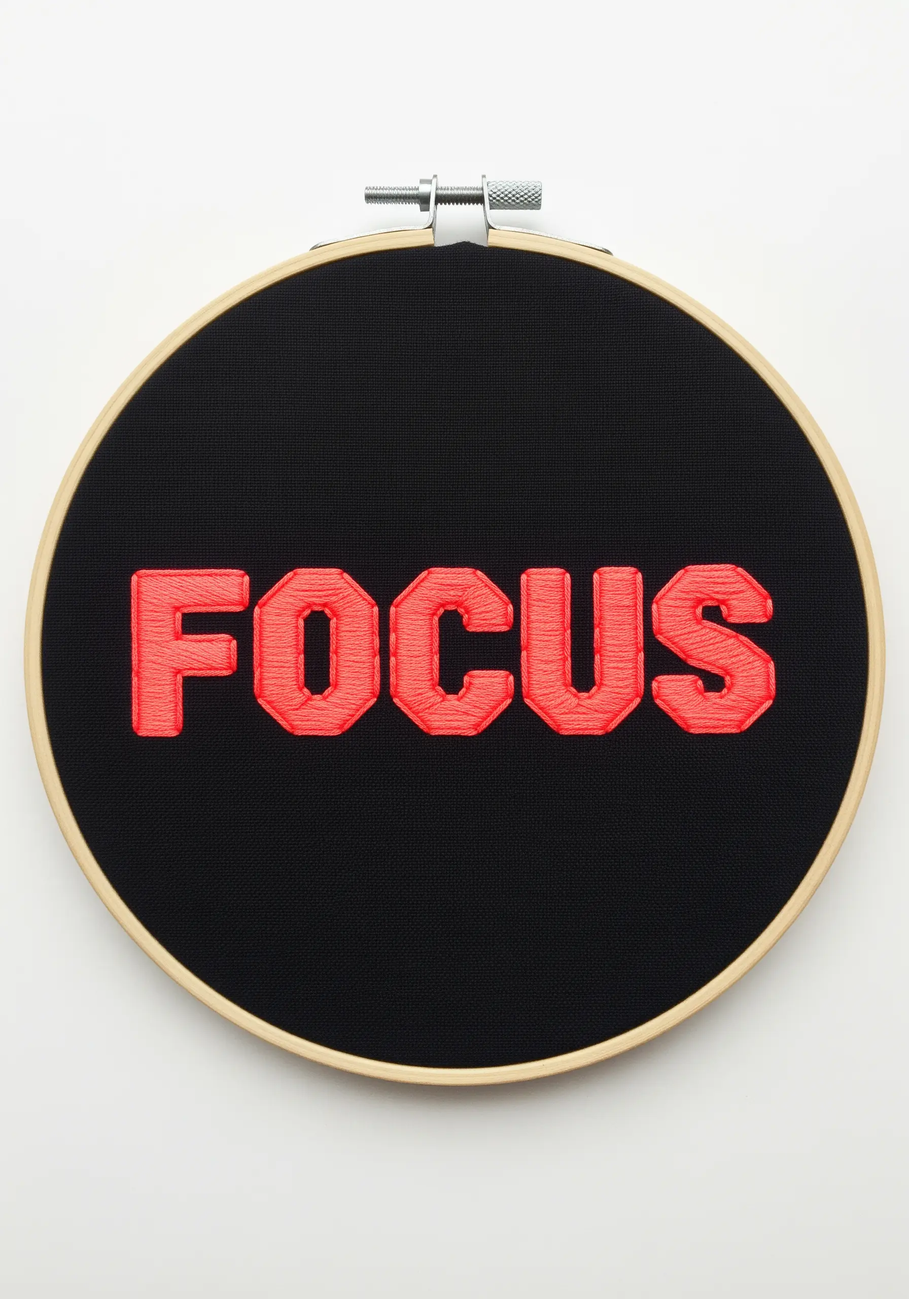 Bold red satin stitch 'FOCUS' embroidery on black fabric