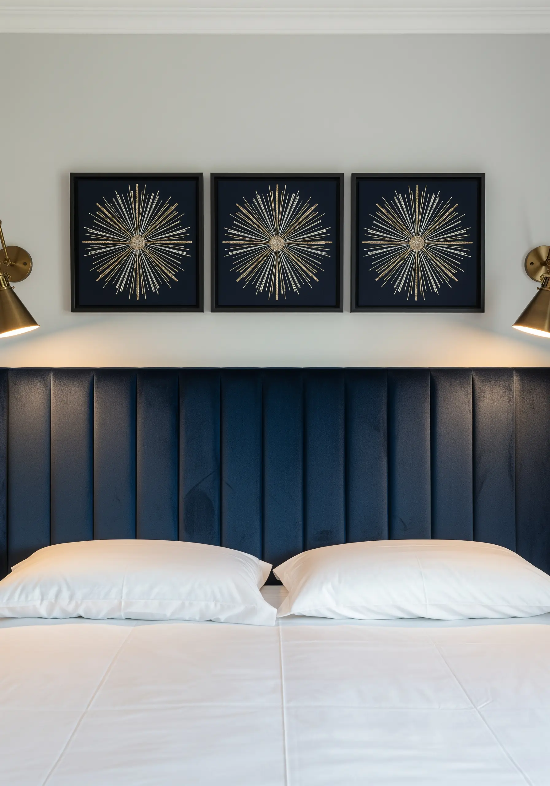 Three framed metallic thread art pieces depicting gold and silver starbursts on dark fabric.