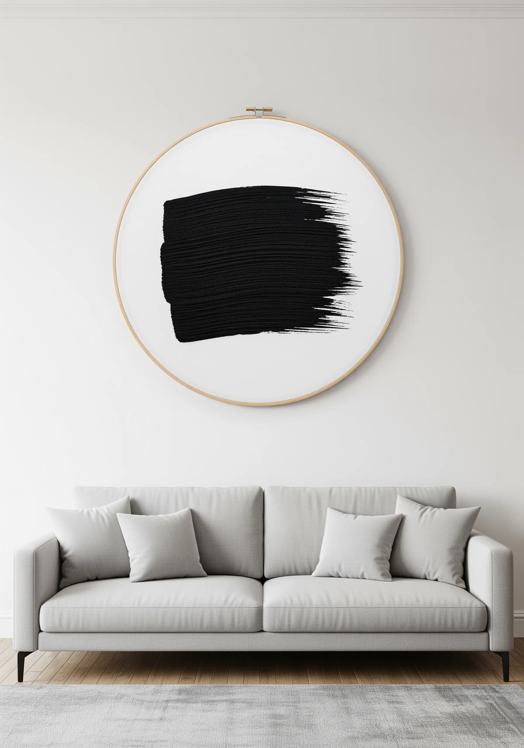 An oversized embroidery hoop with a dense, black-stitched shape mimicking a bold paint brushstroke