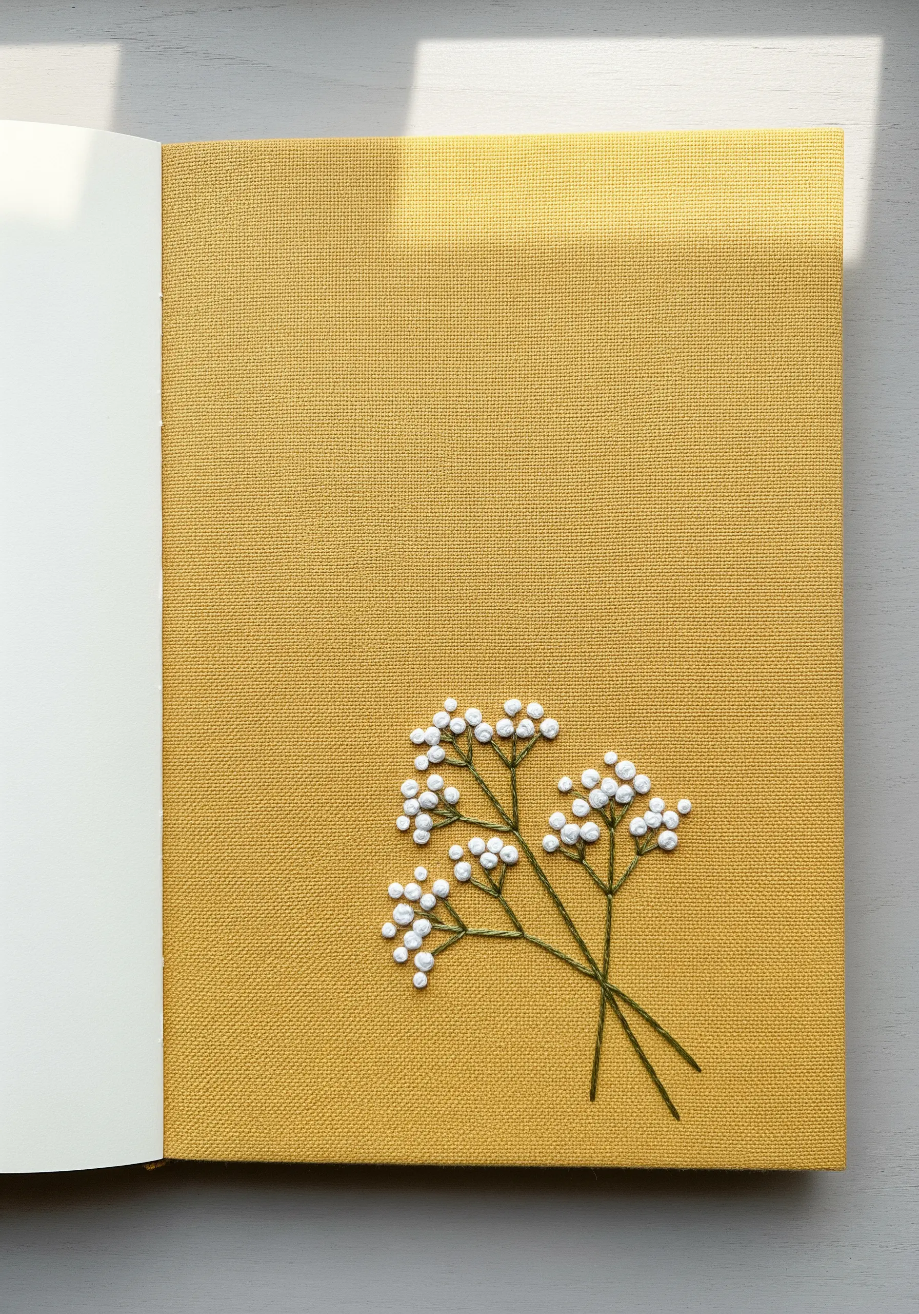 A spray of baby's breath embroidered with white French knots and thin green stems.