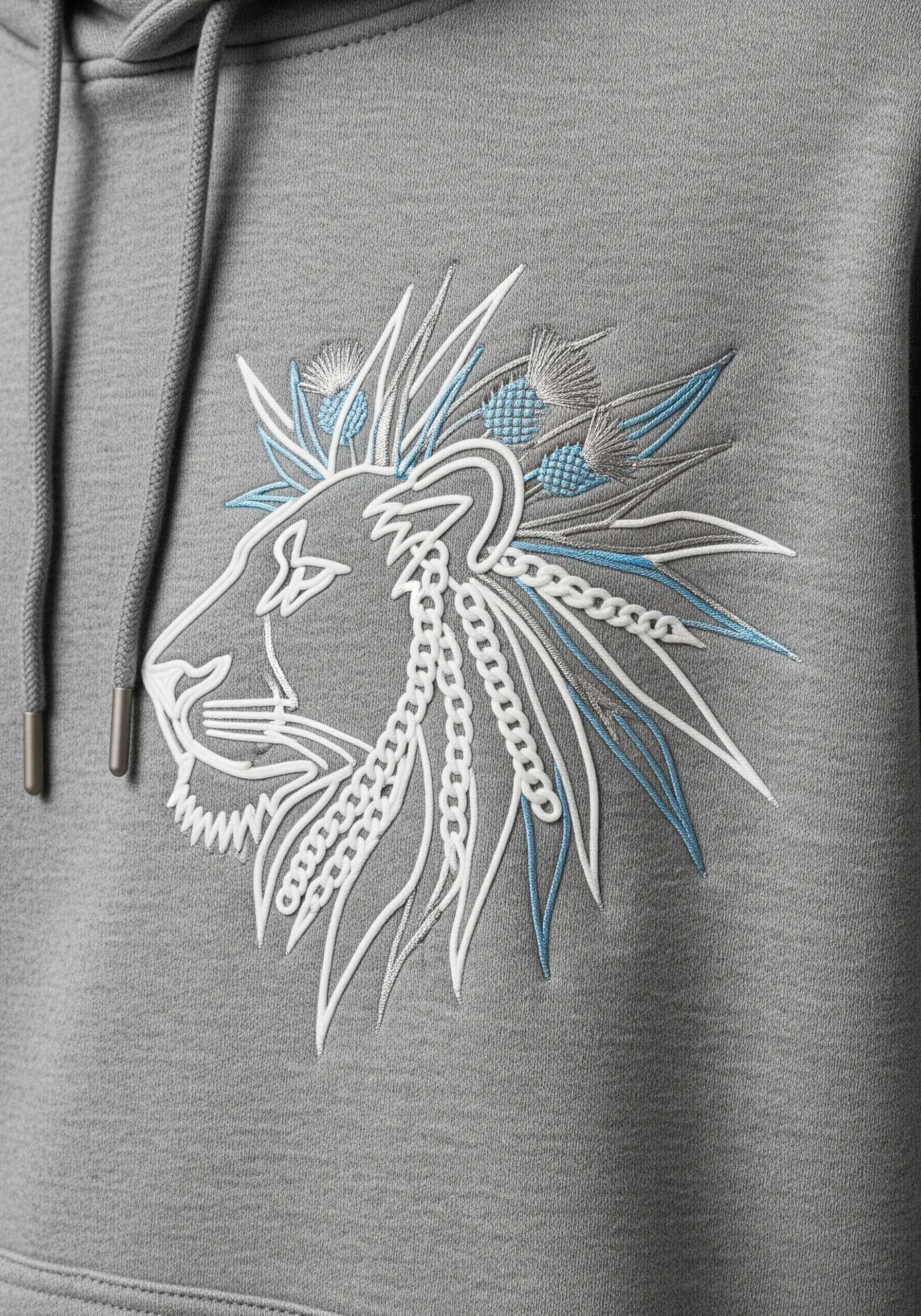 Minimalist line art embroidery of a lion's profile with blue accents on a grey hoodie.