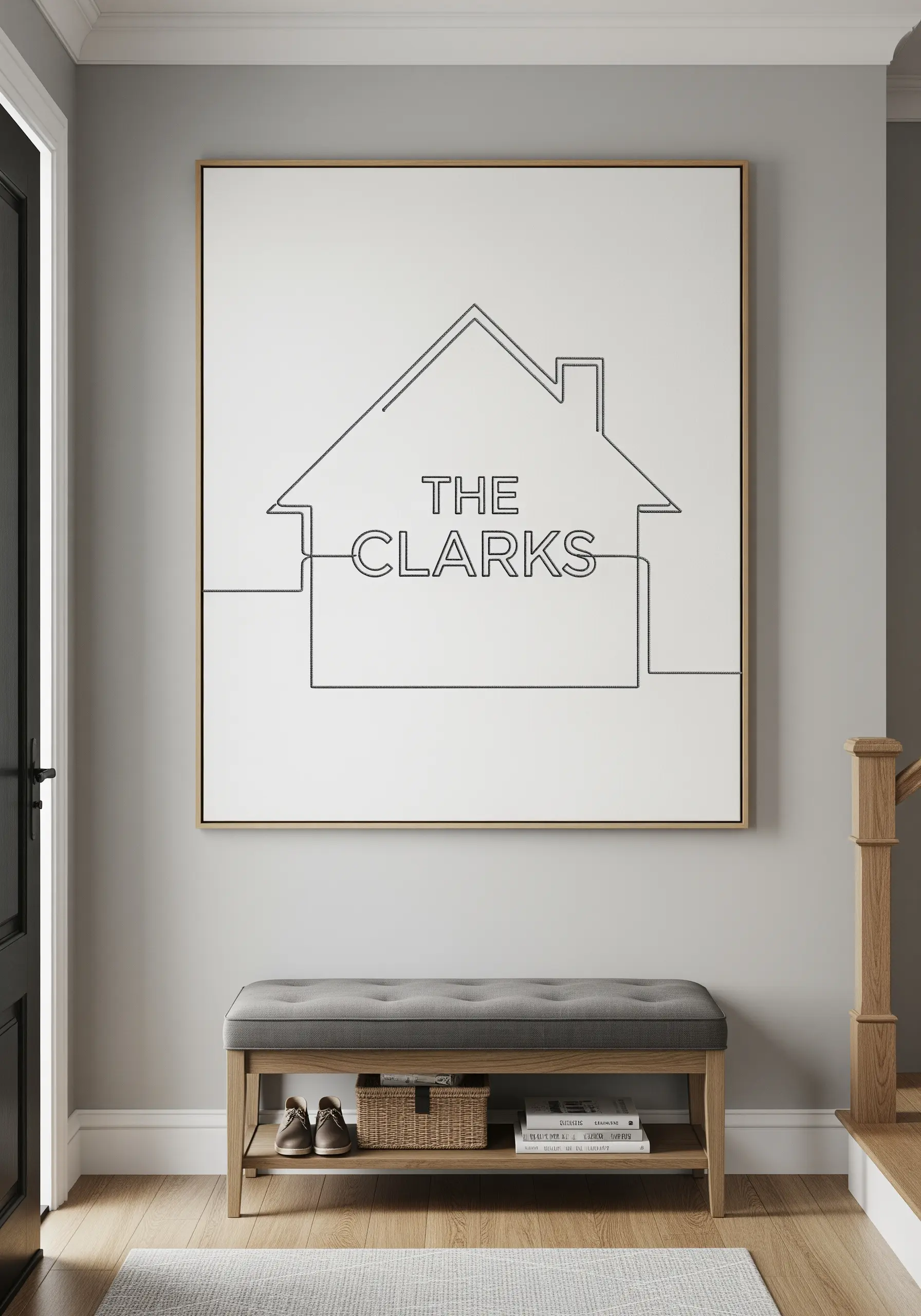 A single-line embroidery of a house outline with the family name 'THE CLARKS' inside.