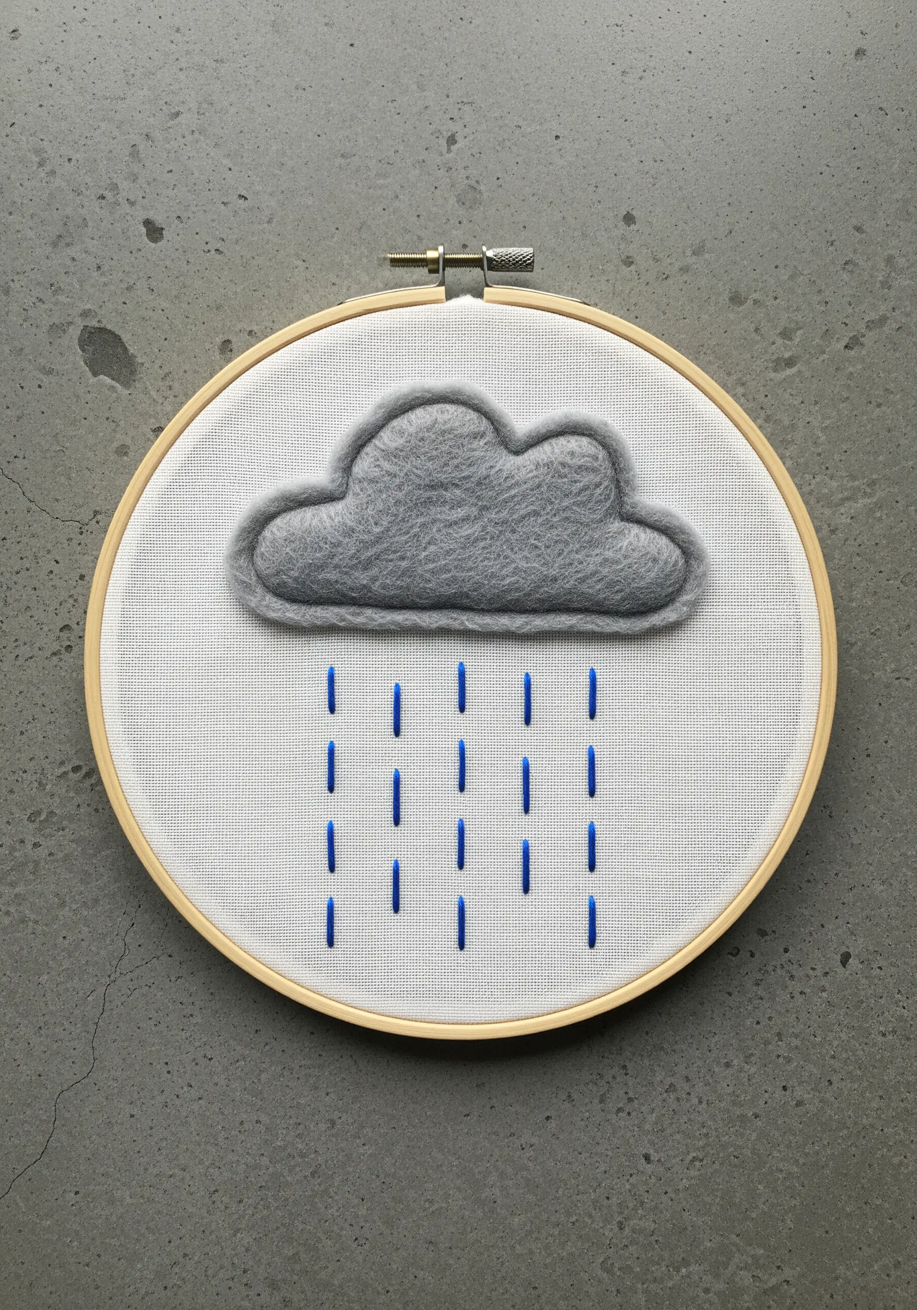 A grey felt cloud with vertical blue straight stitches for rain.