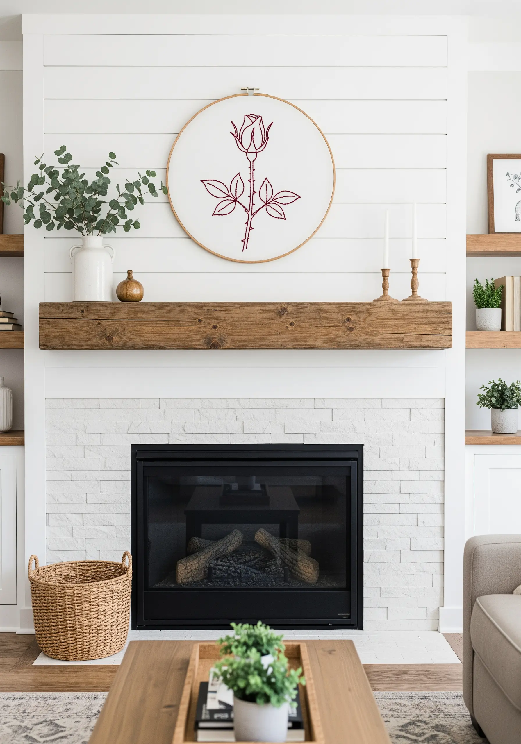 A large, single-color outline embroidery of a rose on a white shiplap wall.