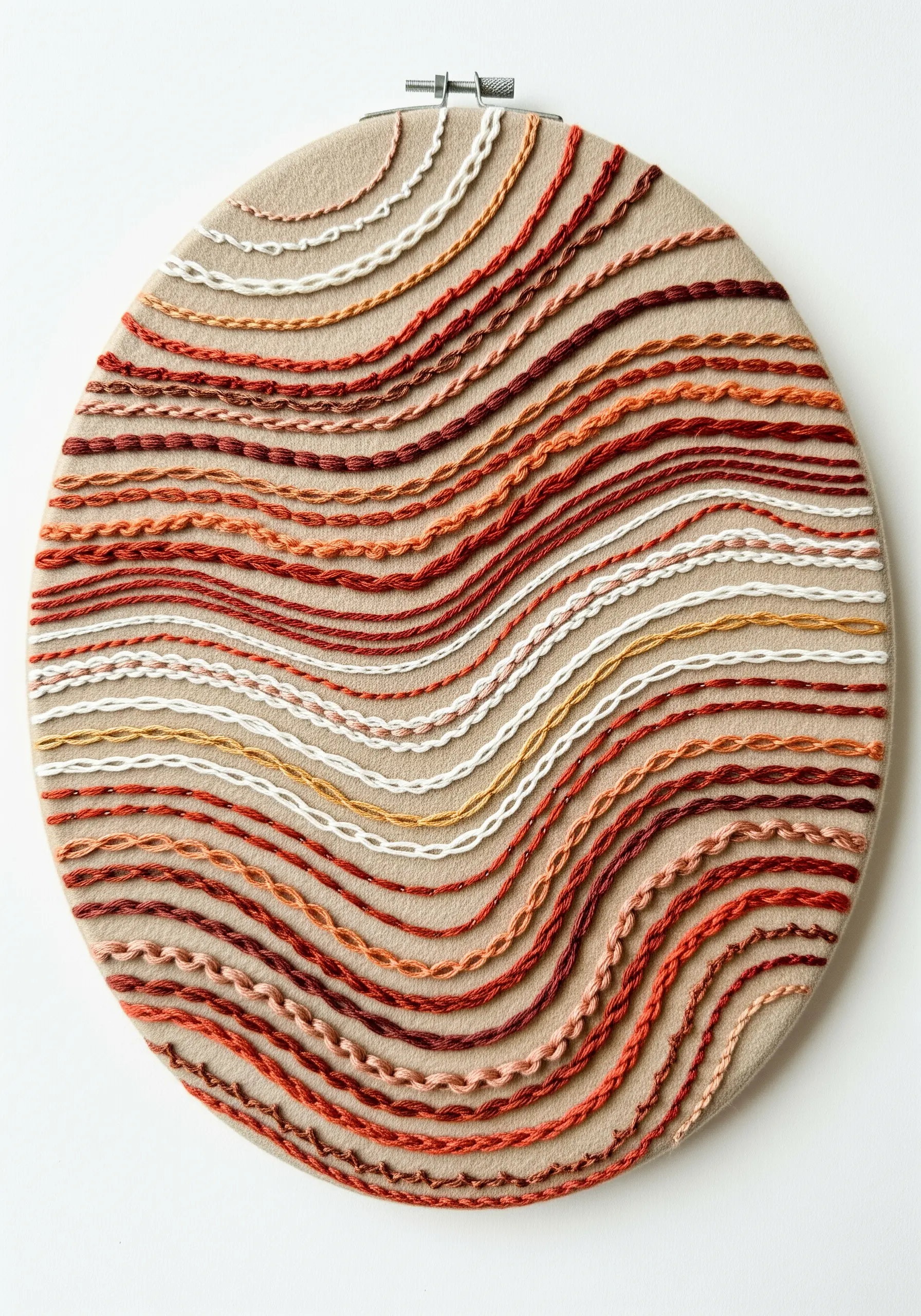 Textured hoop art with wavy lines of variegated red and brown threads in different stitches.