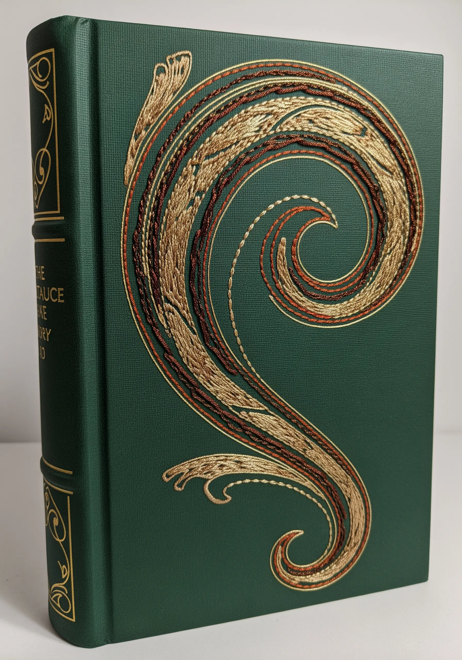 An intricate abstract scrollwork design in gold and copper thread on a green book cover.