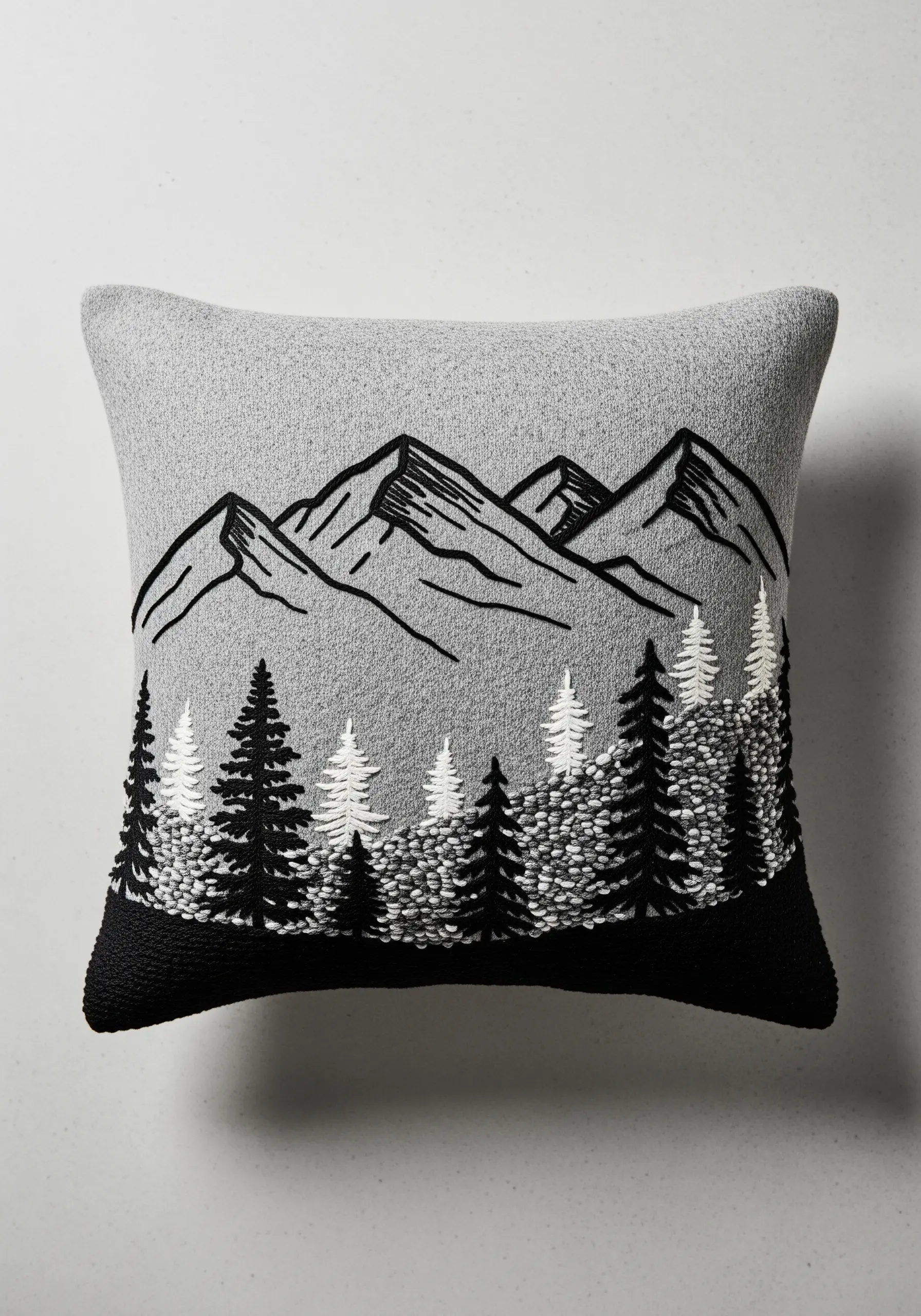 A minimalist mountain range border embroidered with black outlines and French knot trees