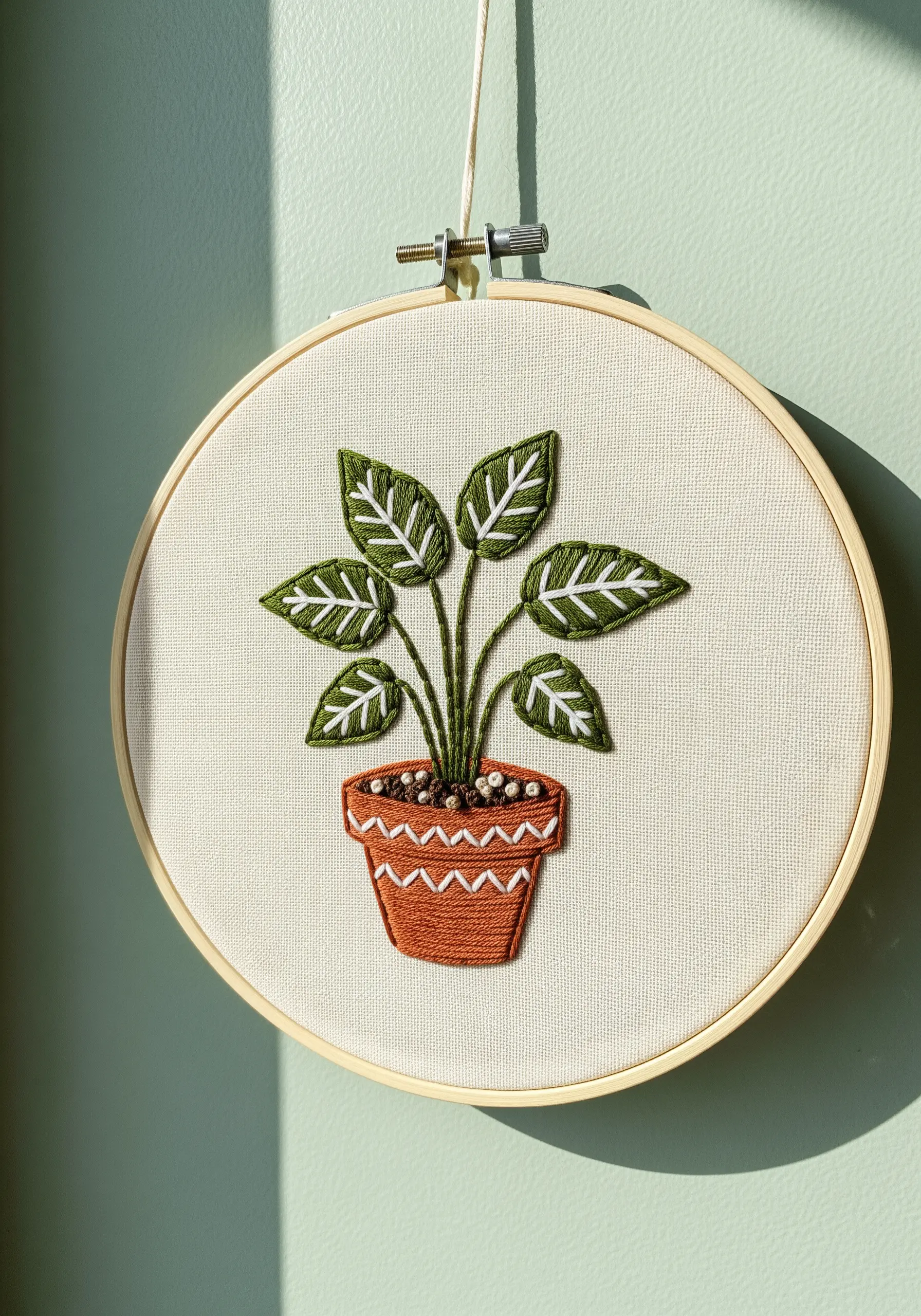 Hoop art of a potted Calathea plant with graphically outlined leaves in dark and light green.