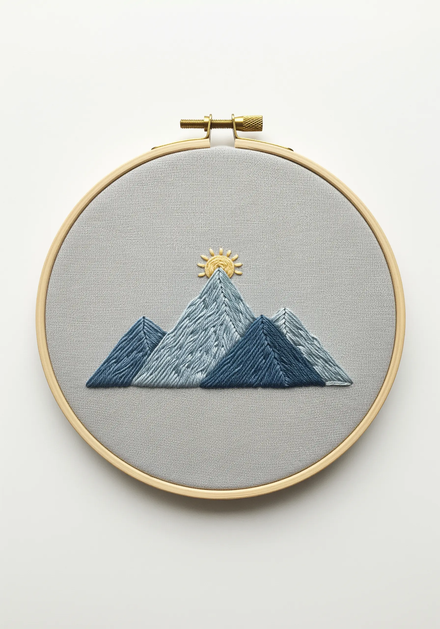Embroidered mountain range with varied blue and white stitches to create texture and depth.