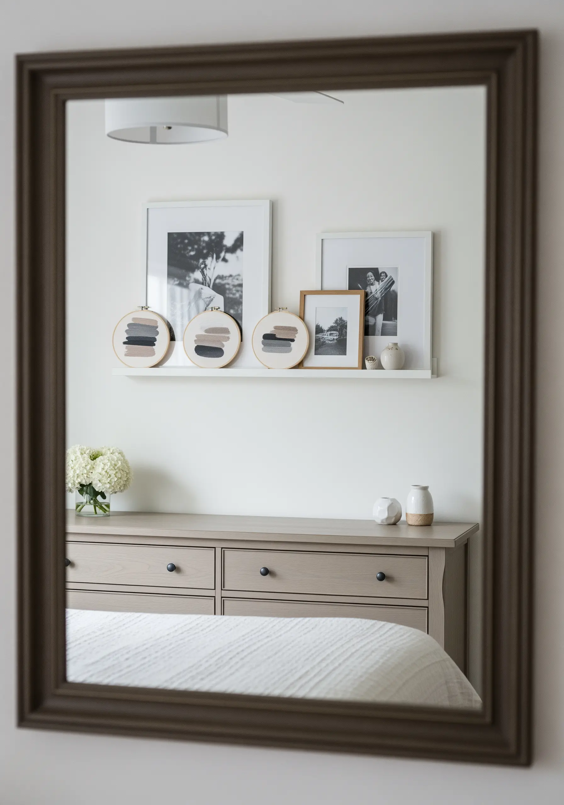 Three small hoops on a shelf, each with abstract 'brushstrokes' of satin stitch in neutral colors.