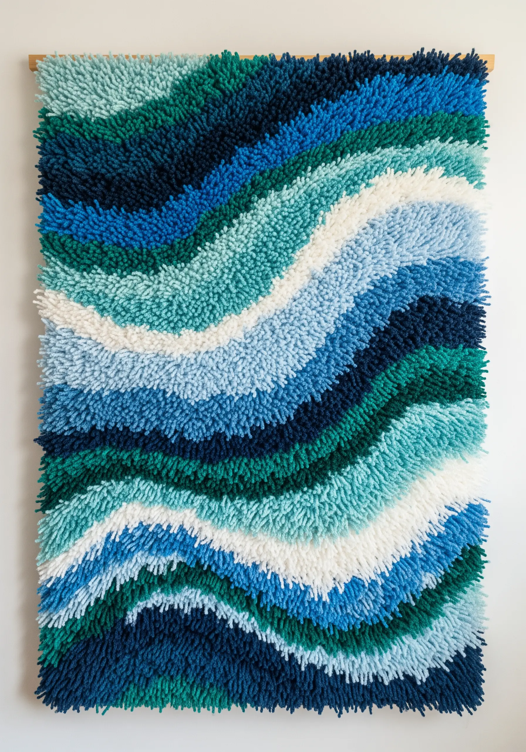 A plush, shag-style wall hanging with wavy lines of blue, green, and white yarn.
