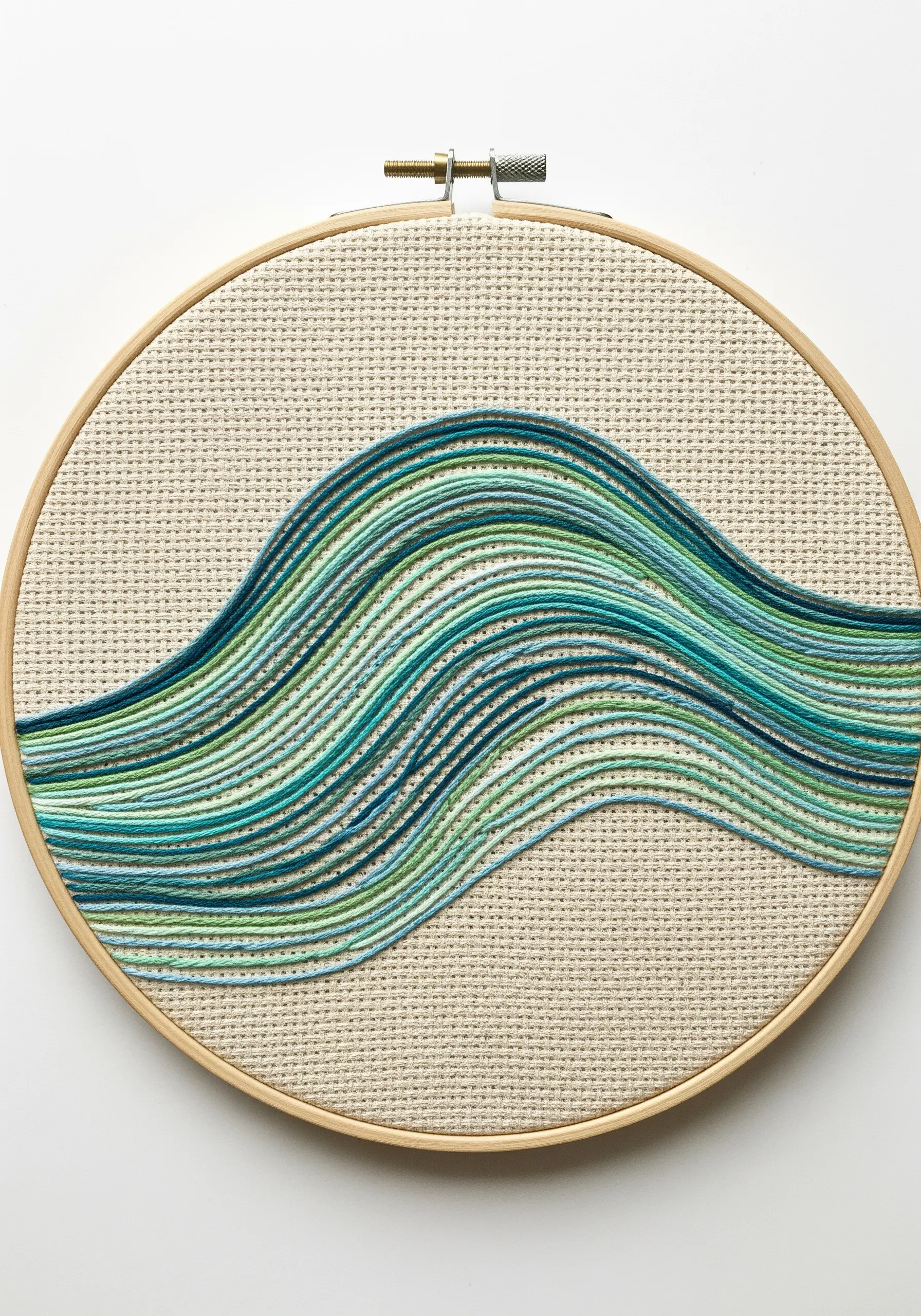Abstract wave made of horizontal stitches in shades of blue and green.