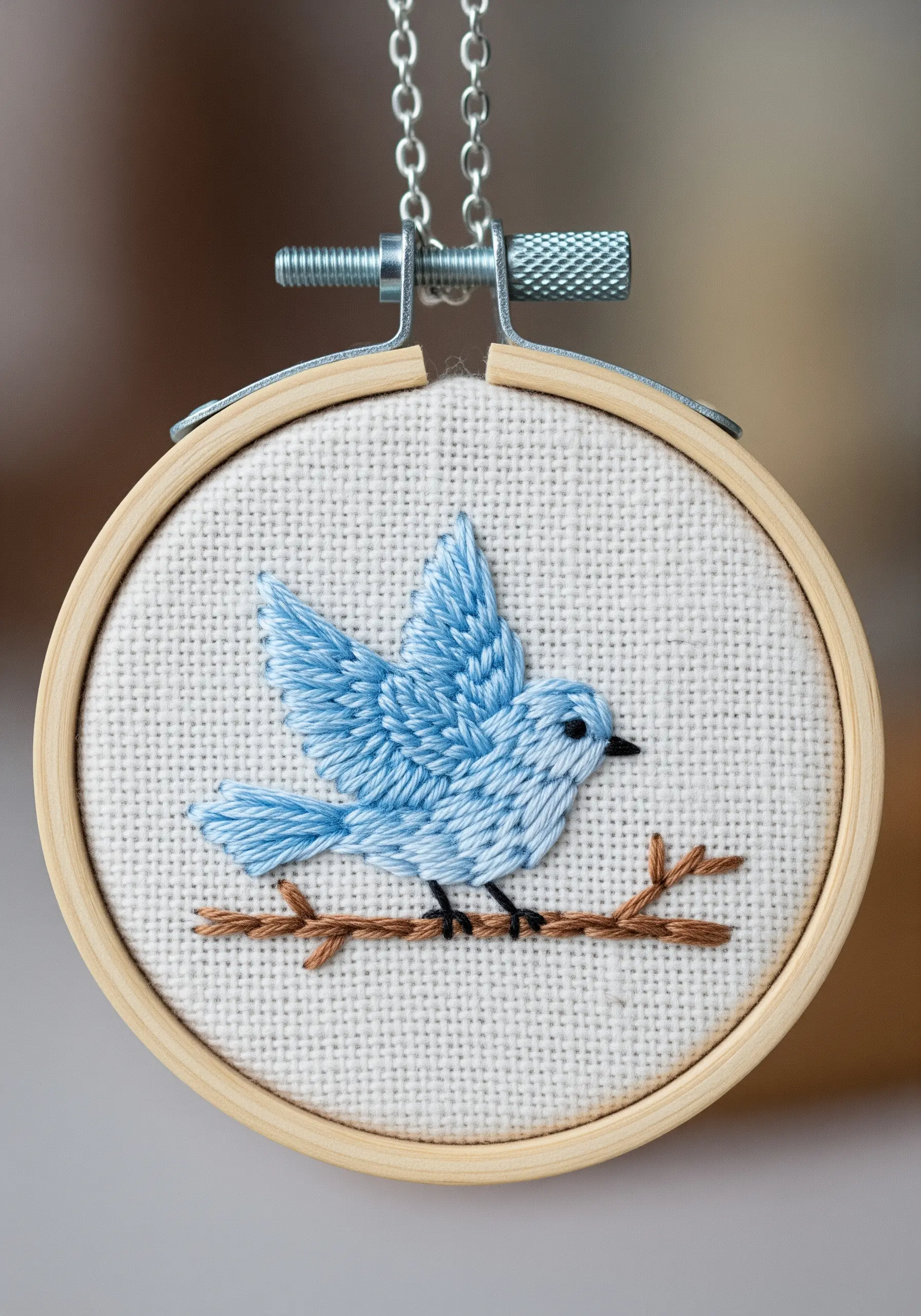 A small bluebird embroidered in a mini hoop, suitable for a necklace pendant.