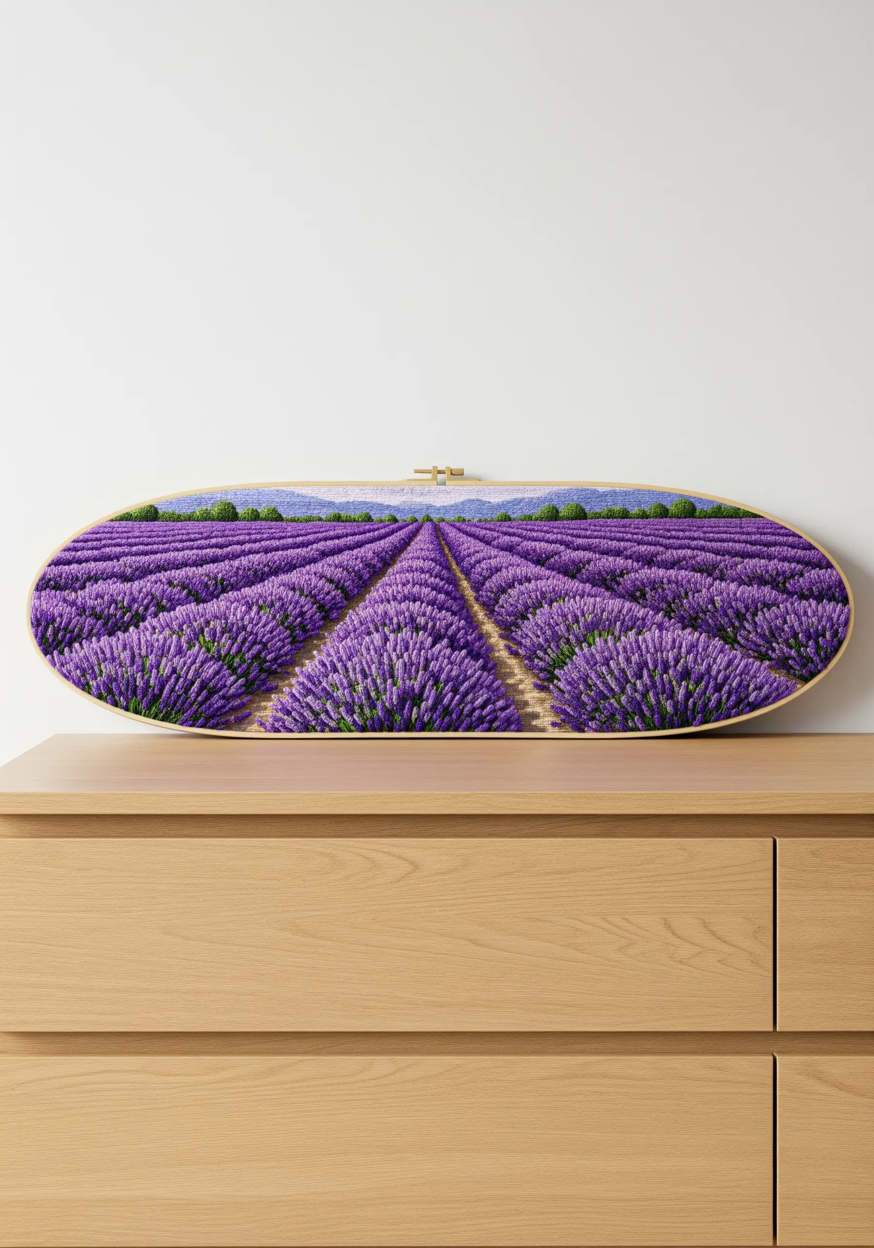 A panoramic, oval-shaped embroidery hoop filled with a detailed lavender field scene.