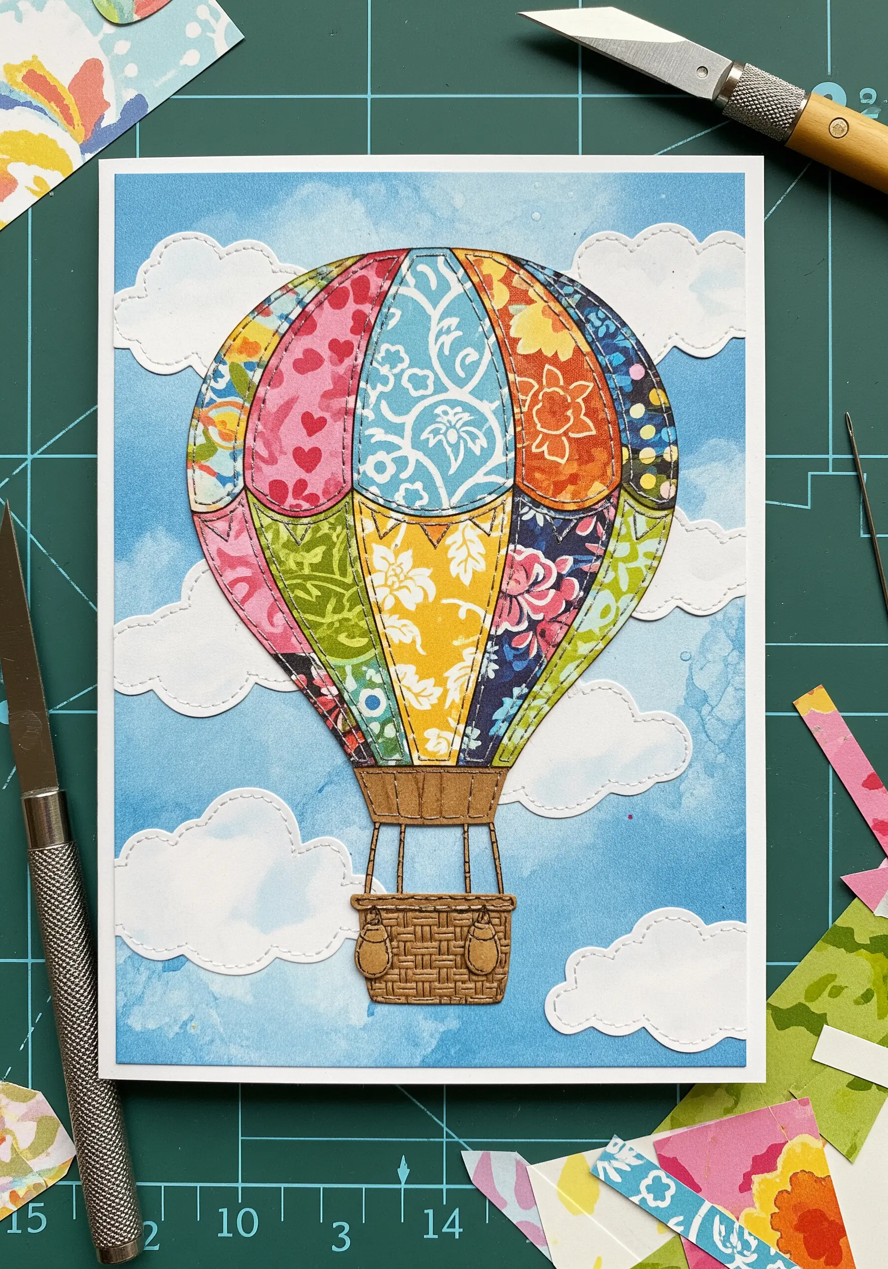 A hot air balloon made from patchwork paper pieces, outlined with decorative stitching.