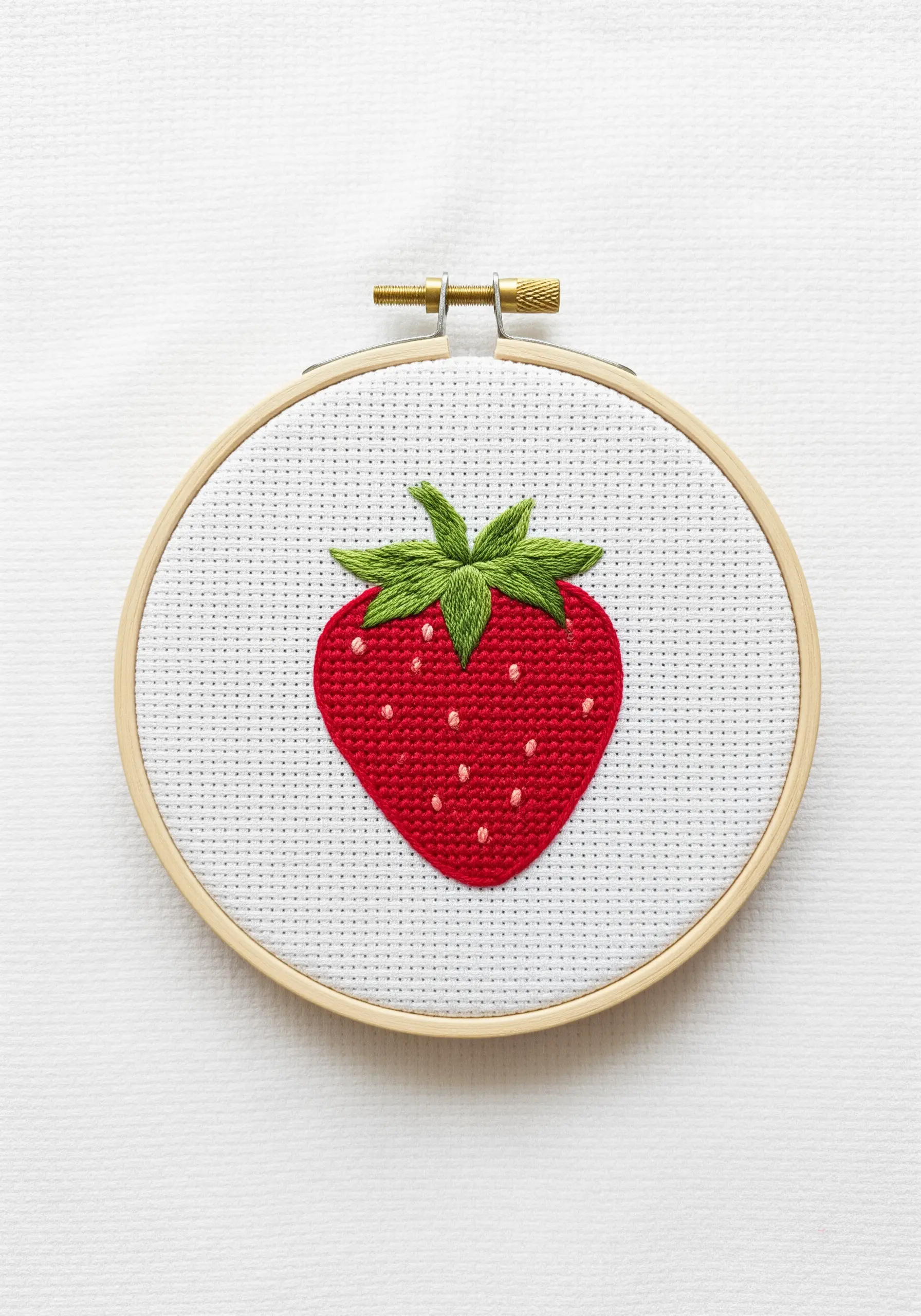 A perfectly filled satin-stitched strawberry with a clean edge and tiny seed details.