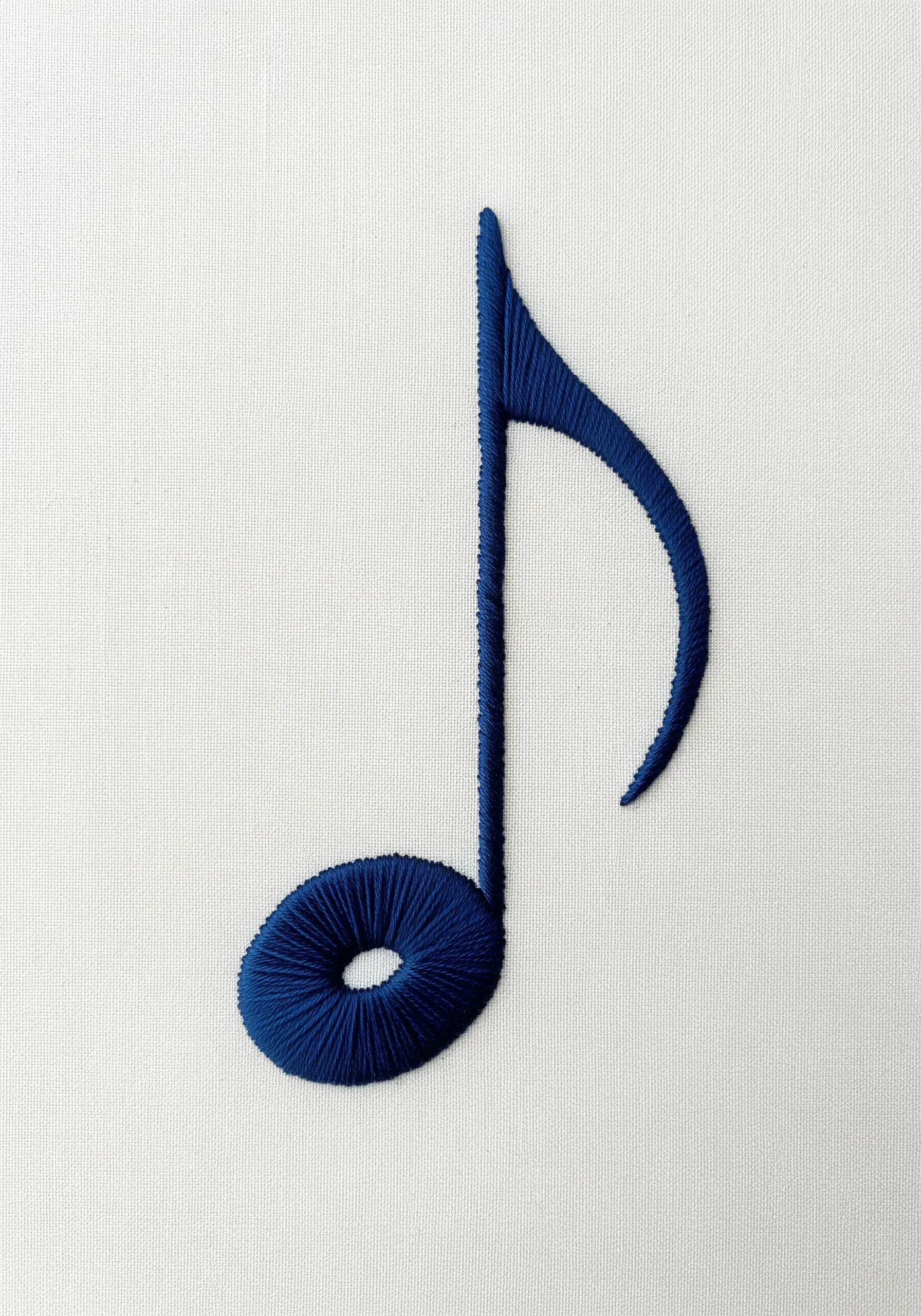 A single blue musical note filled with perfectly smooth, angled satin stitch on white fabric.