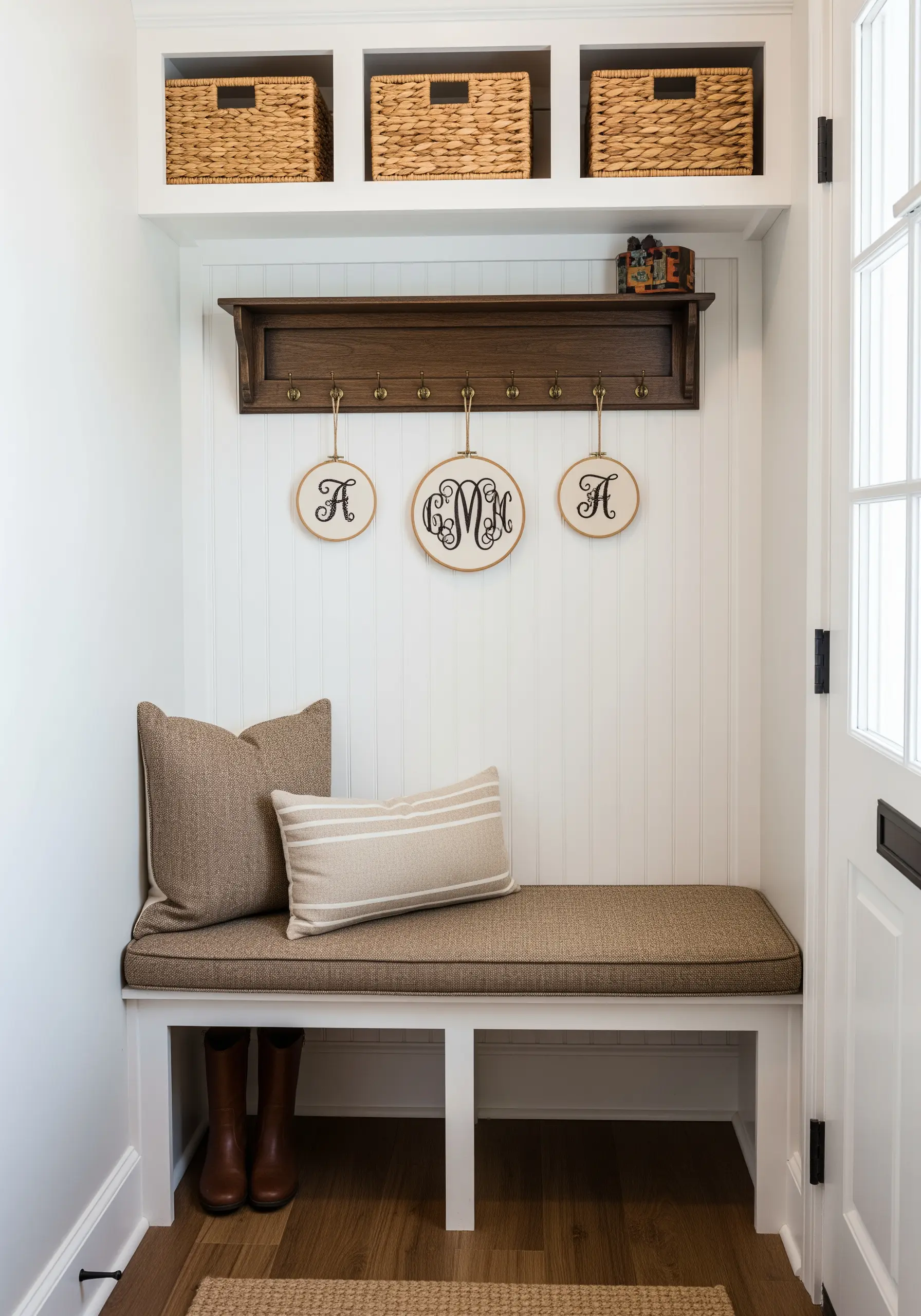 Three elegant monogram embroidery hoops hanging above hooks in a modern farmhouse mudroom.