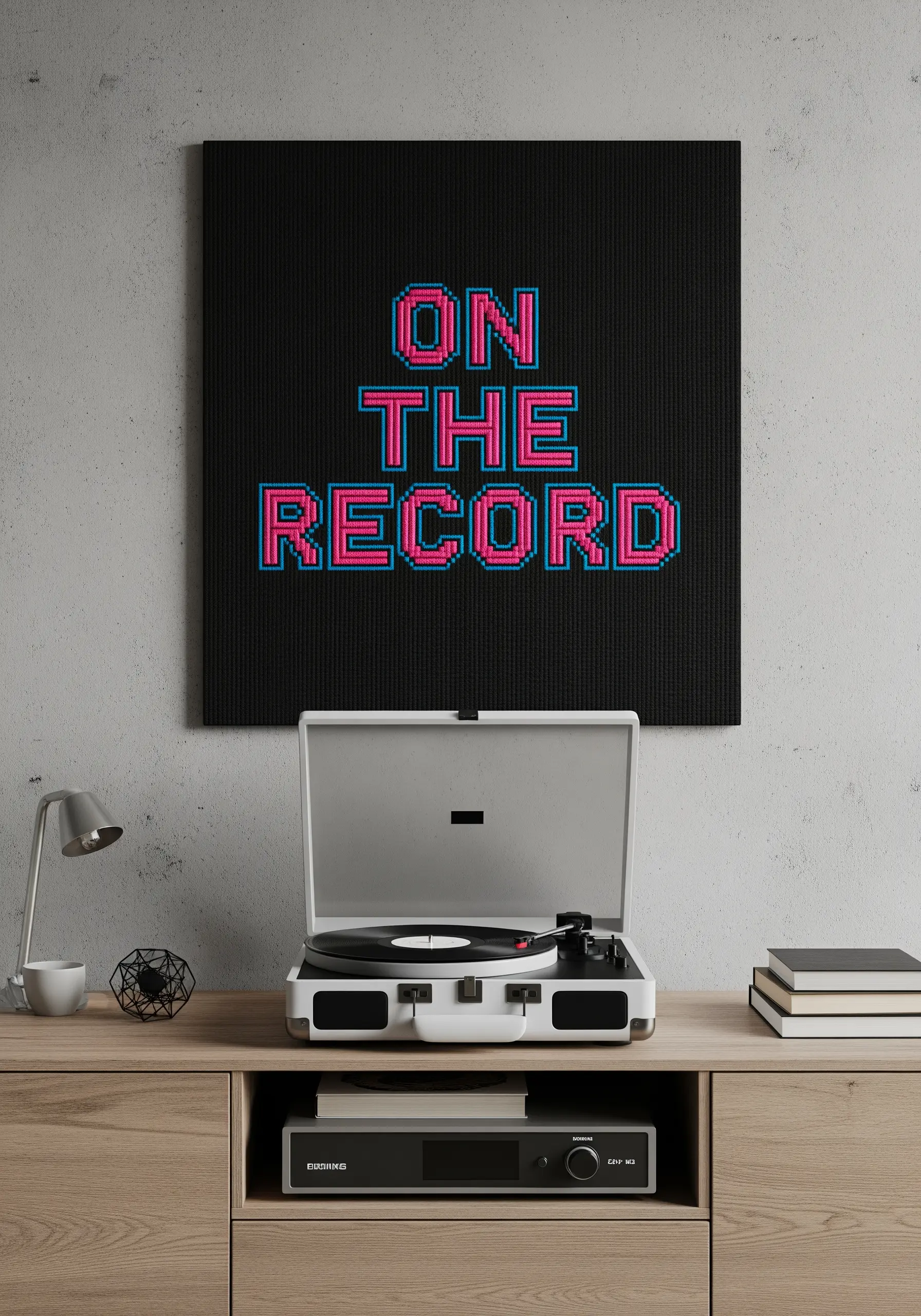 The phrase 'ON THE RECORD' in a pixelated, 8-bit style with bright pink and blue thread.