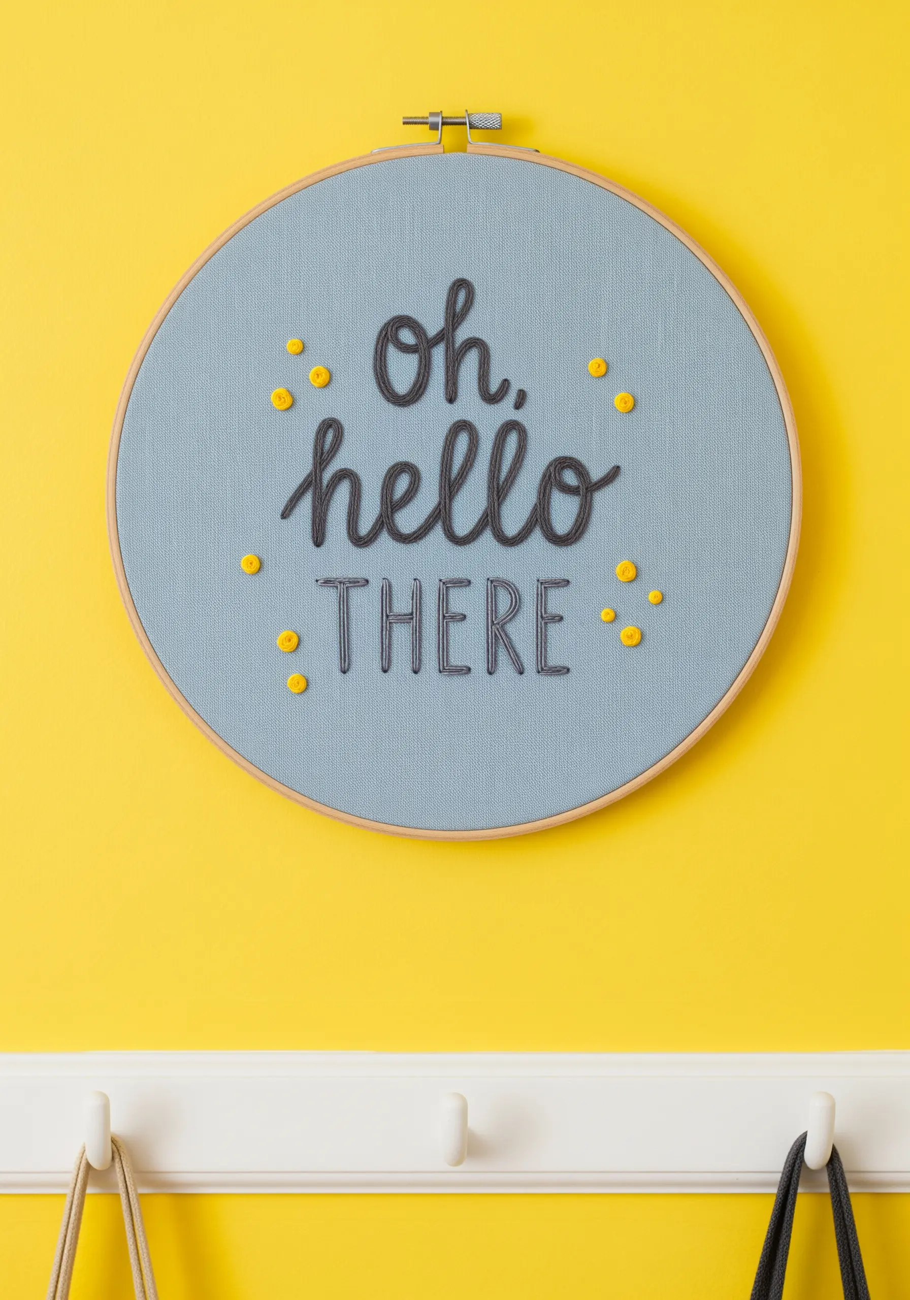 Embroidered 'oh, hello THERE' in grey script with scattered yellow French knots.