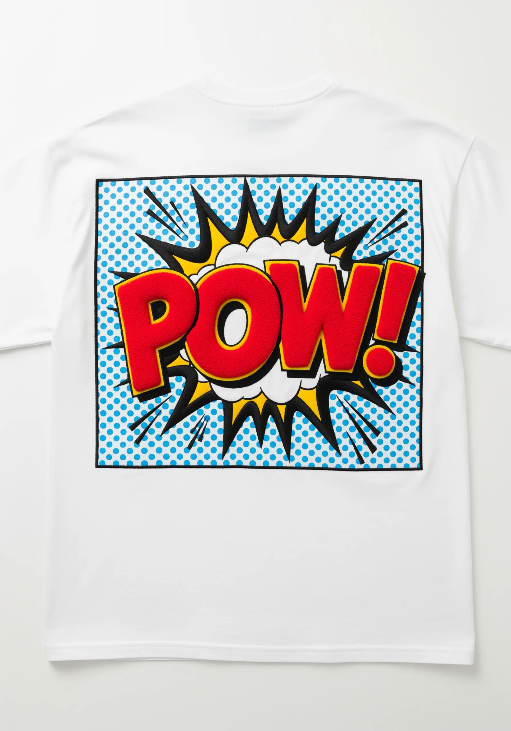 'POW!' comic book graphic embroidered on a white t-shirt with a blue dot background.