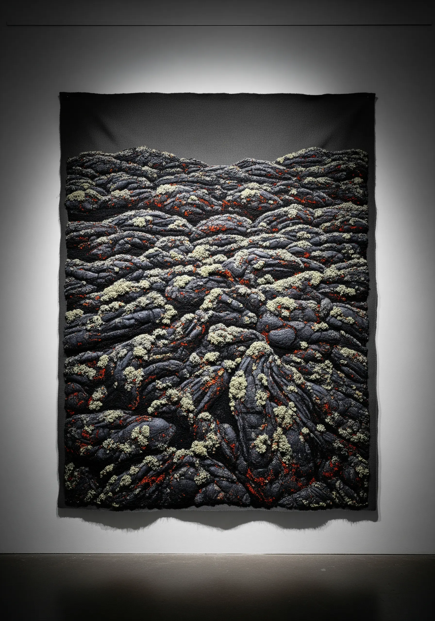 A dark, highly textured tapestry mimicking volcanic rock with small flecks of lichen.