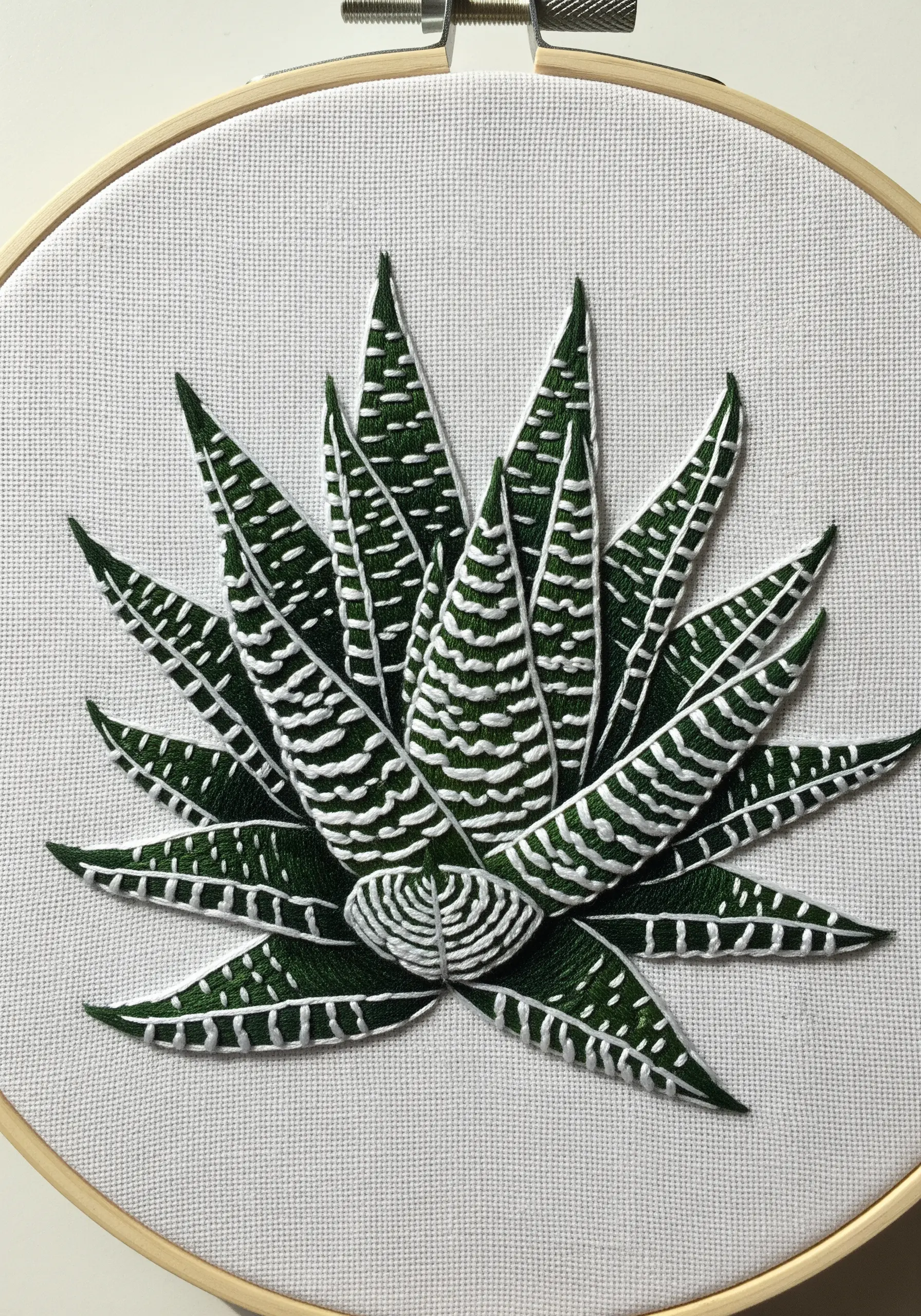 An embroidered Haworthia Zebra Plant with precise white satin stitch stripes on green leaves.