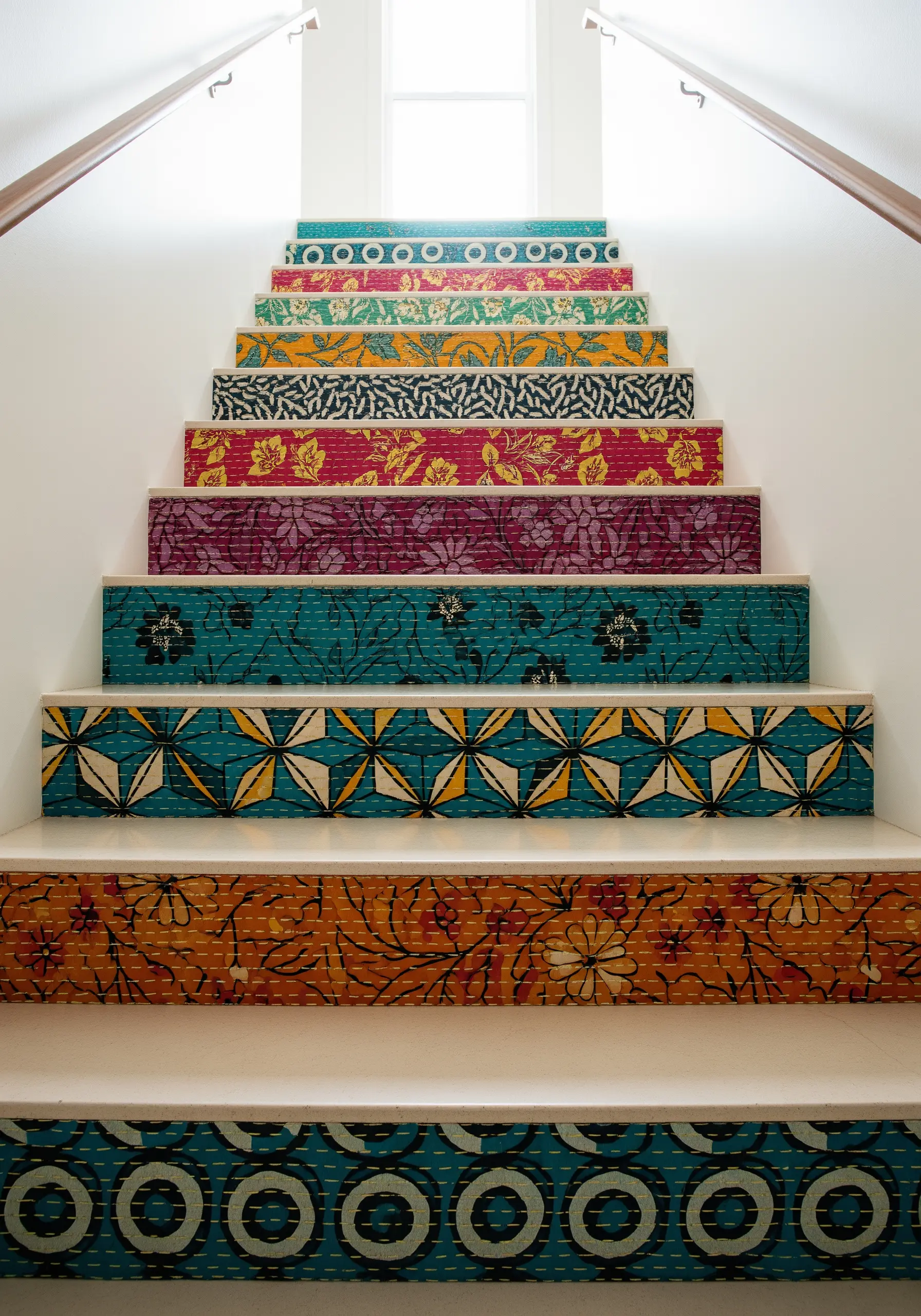 Stair risers decorated with a patchwork of colorful, stitched Kantha quilt fabrics.