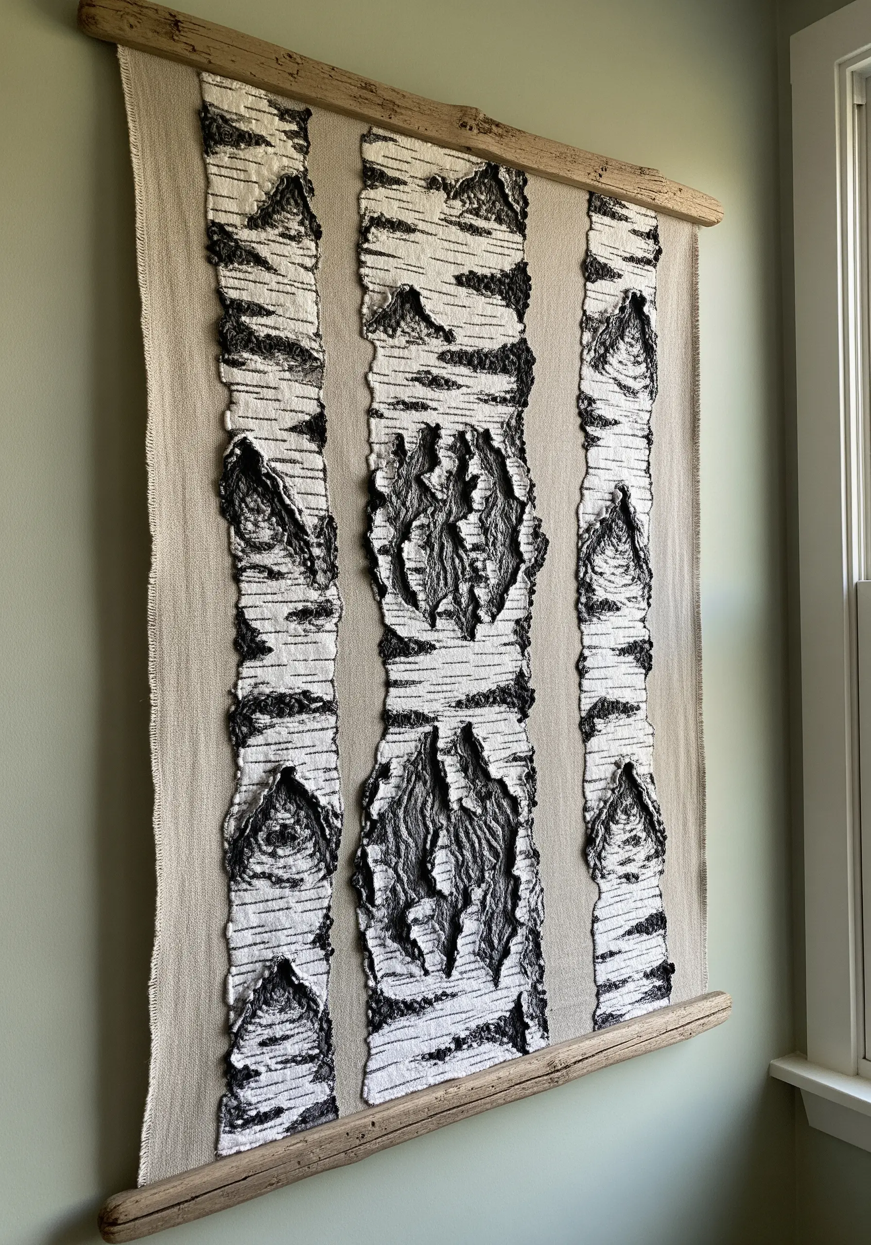 Large textile wall hanging with textured, layered embroidery resembling birch bark.