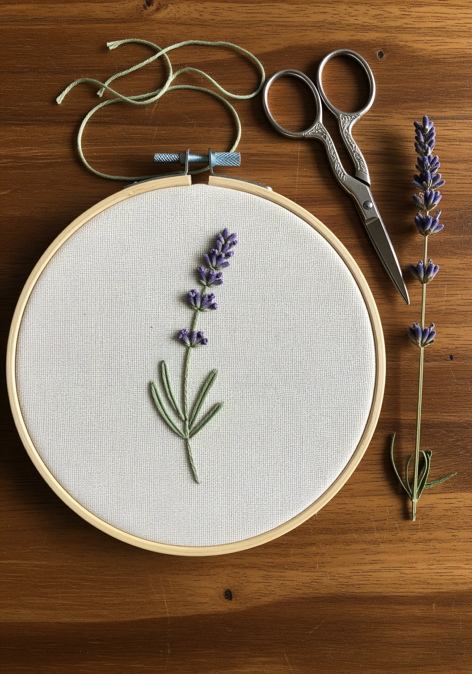 Minimalist lavender embroidery with French knot flowers and stem stitch leaves in a wooden hoop.