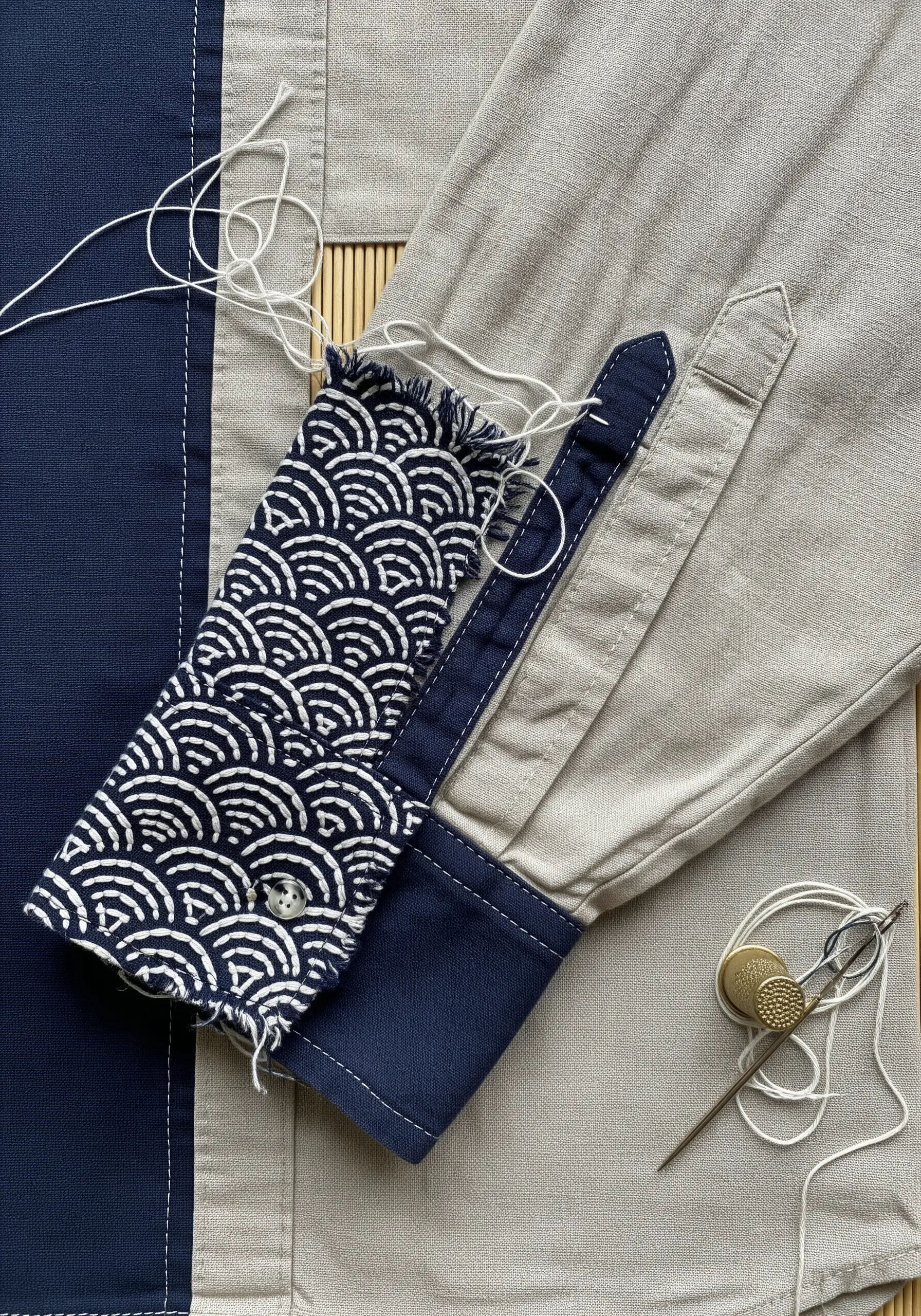 Repairing a shirt by replacing the cuff with a contrasting patterned fabric scrap.